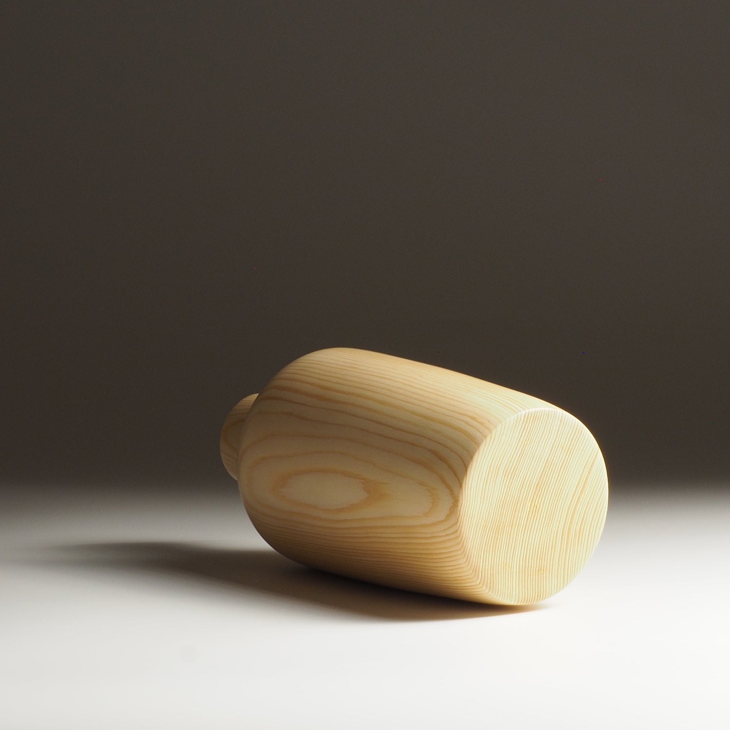 Japanese wooden vase on a dark beige background. Tsukushi