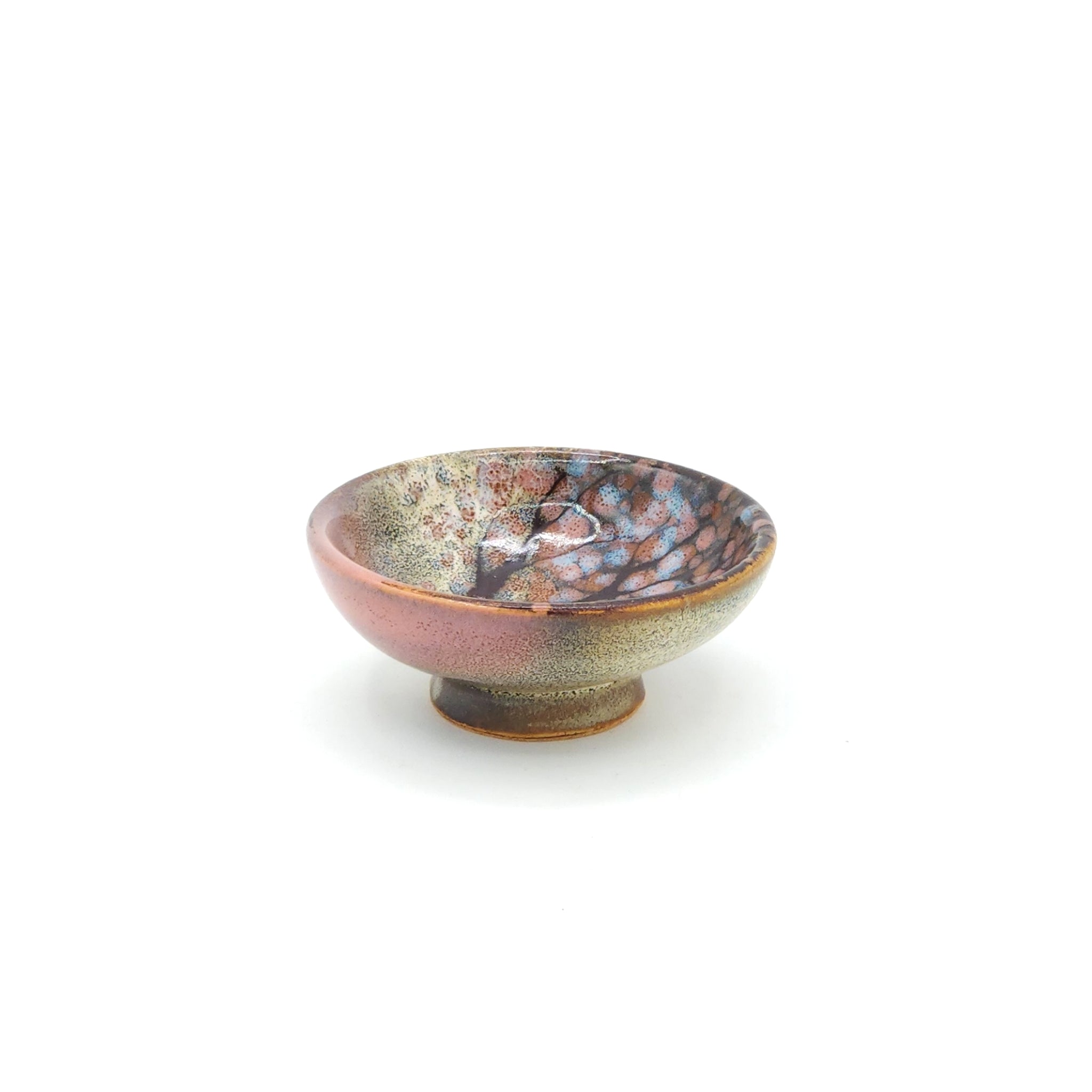 Front view of a flat Japanese ceramic sake cup with a cherry blossom motif. Tsukushi