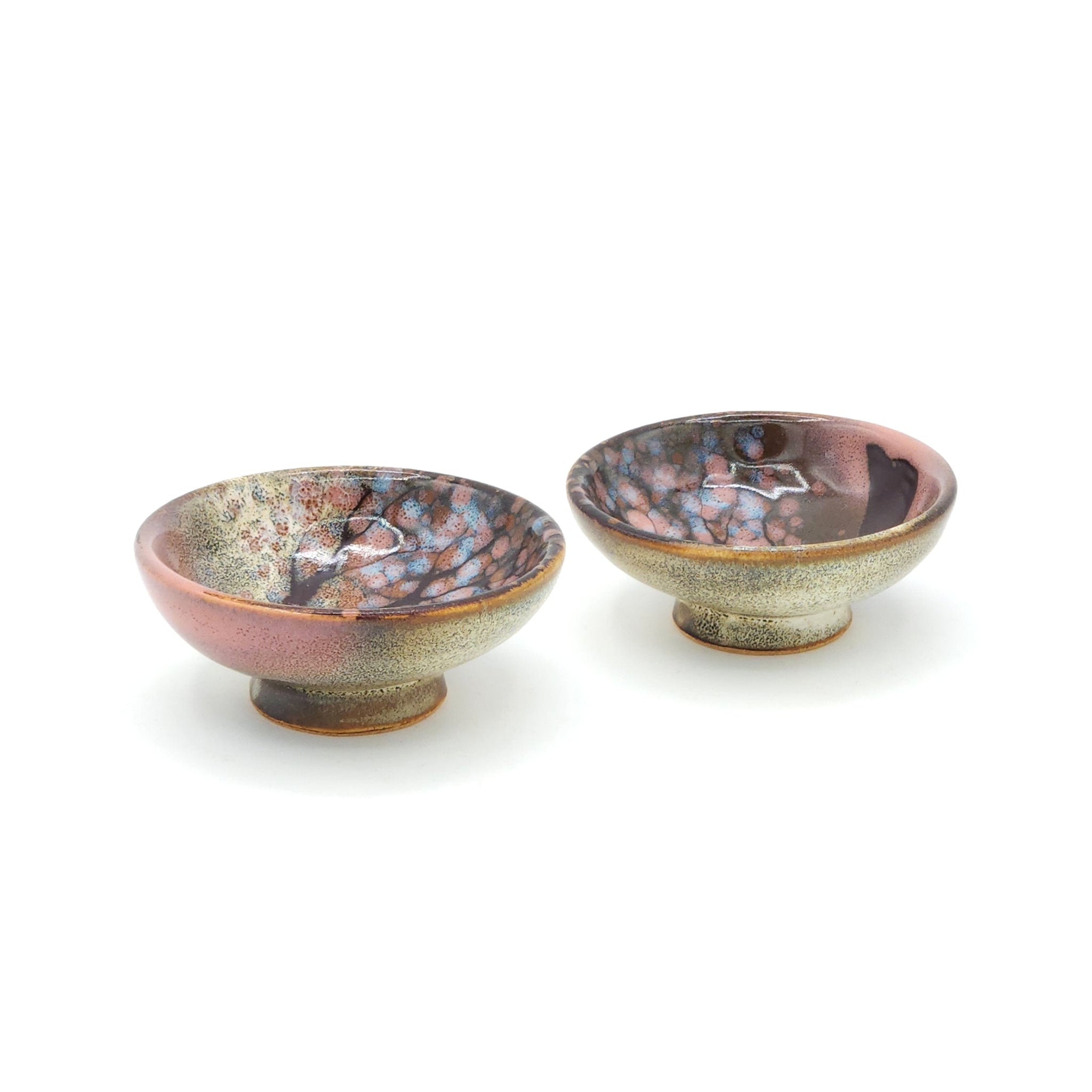A set of two flat Japanese ceramic sake cups with a cherry blossom motif. Tsukushi