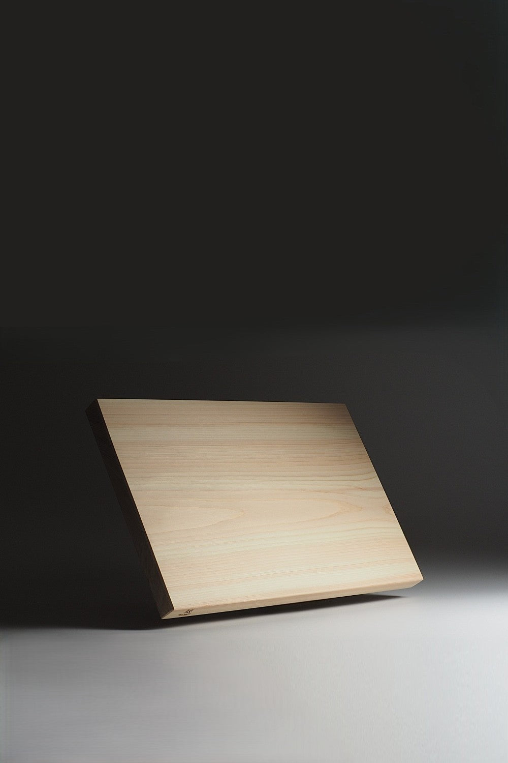 Japanese hinoki wood cutting board on a dark background. Tsukushi