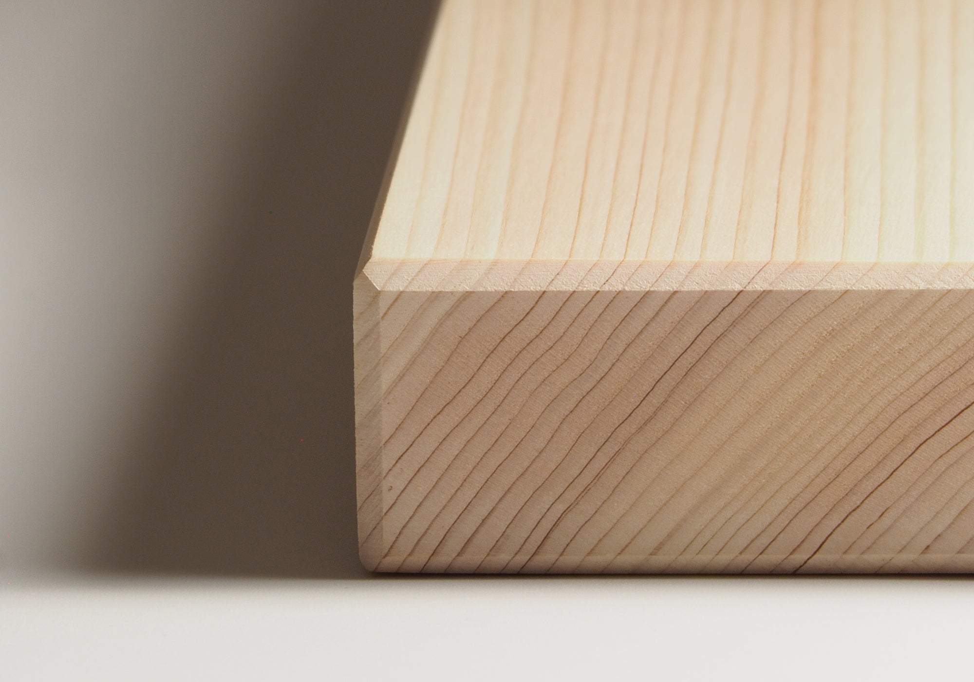 Close-up of a wooden Japanese cutting board on a neutral background. Tsukushi
