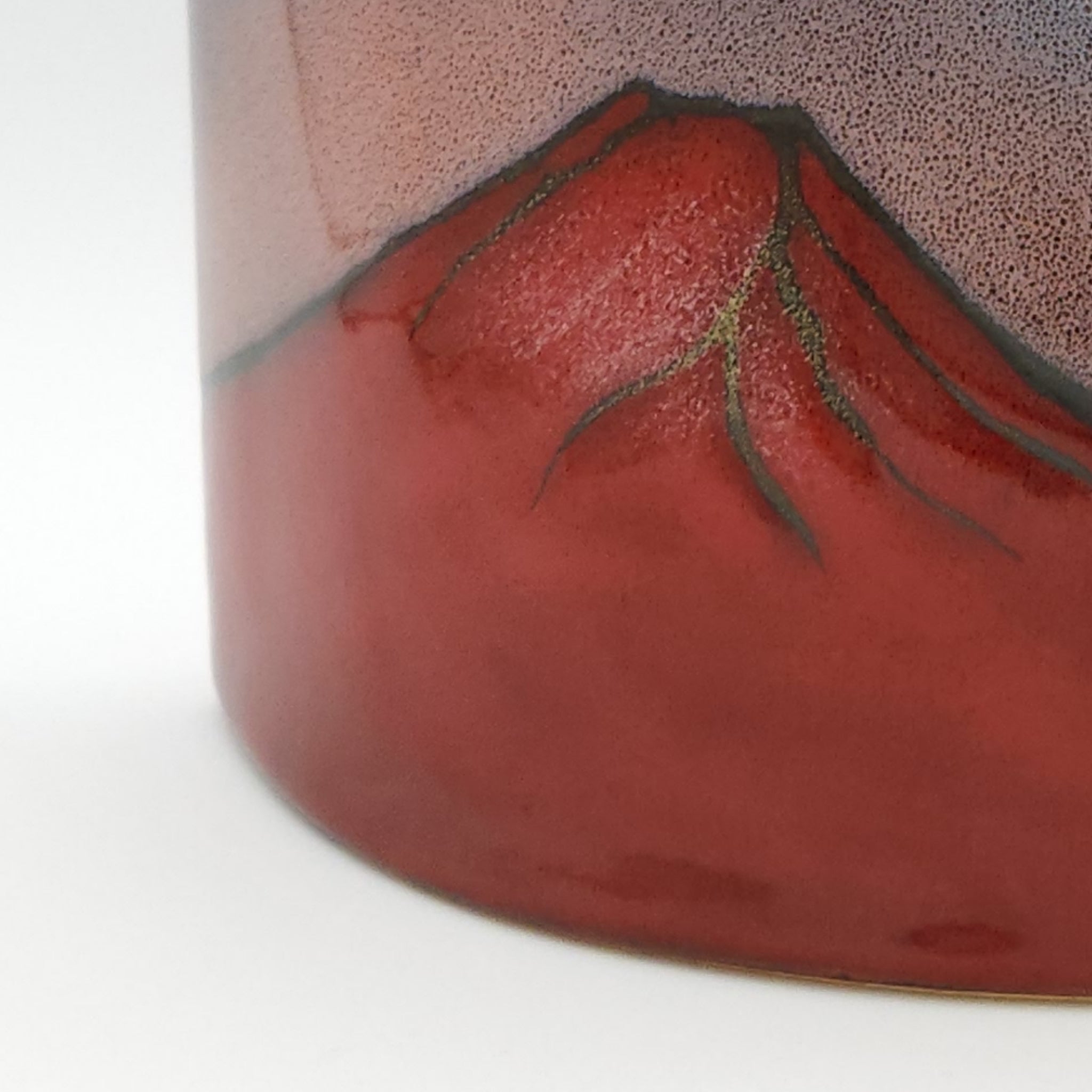 Detail view of a Japanese pottery ornament with a red Mt. Fuji decoration. Tsukushi