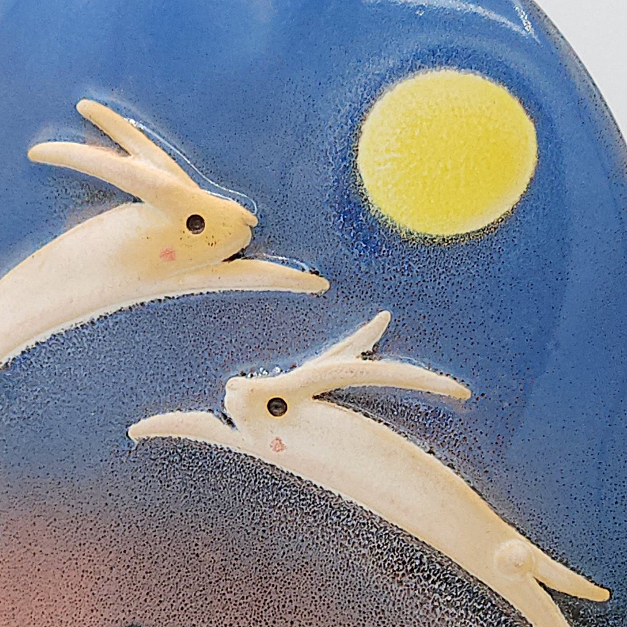 Detail view of a Japanese pottery ornament with a dancing rabbits and full moon. Tsukushi
