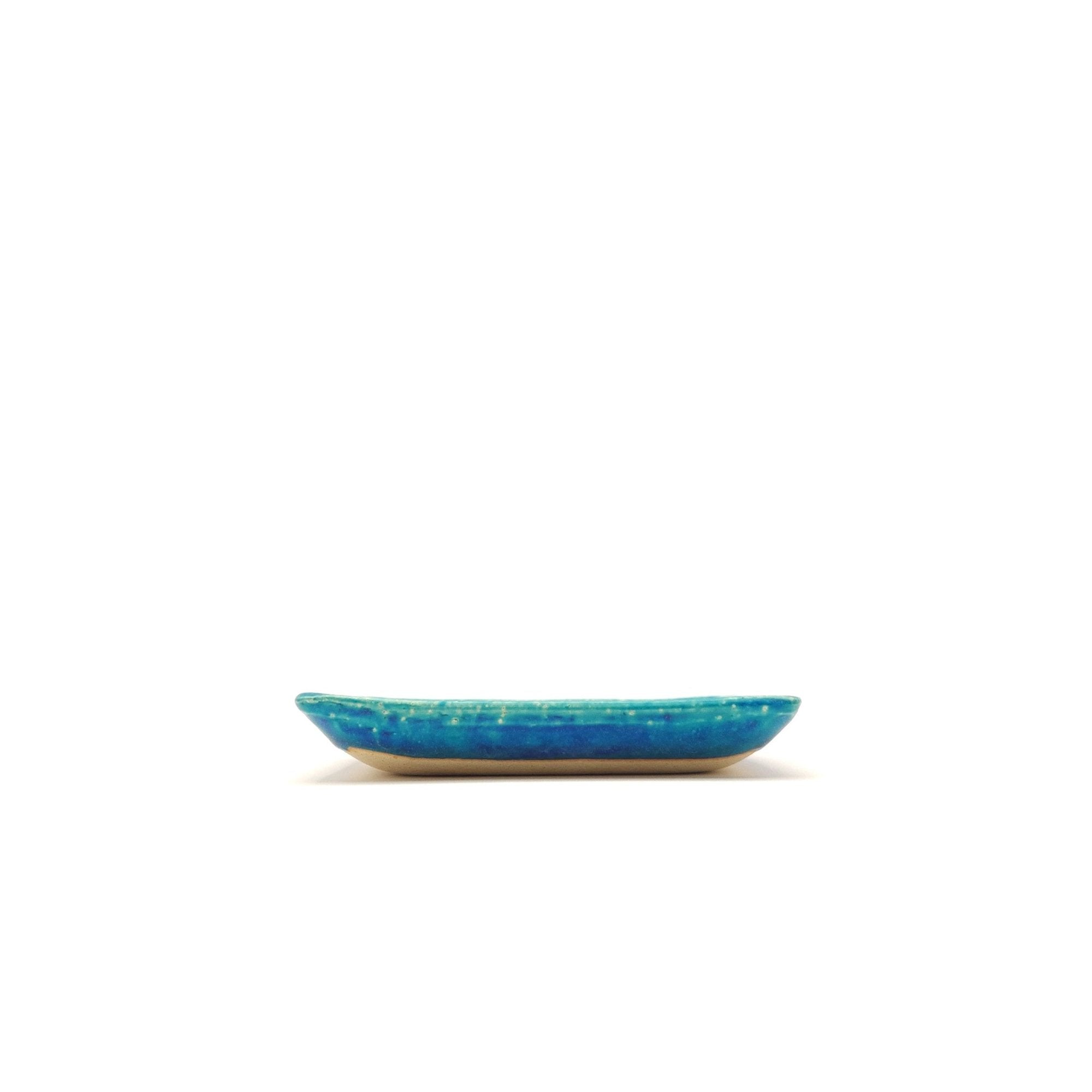 Side view of a turquoise Japanese pottery plate measuring 13cm (5.1")