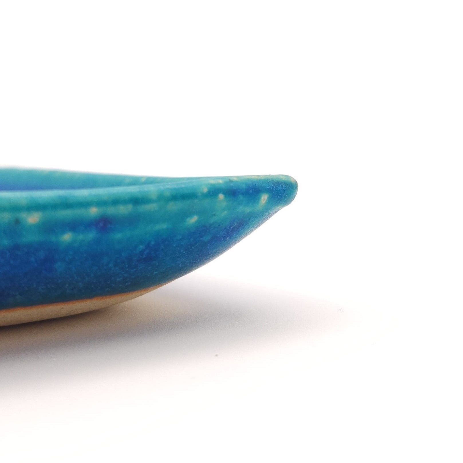 Side close up of a turquoise Japanese pottery plate measuring 13cm (5.1")