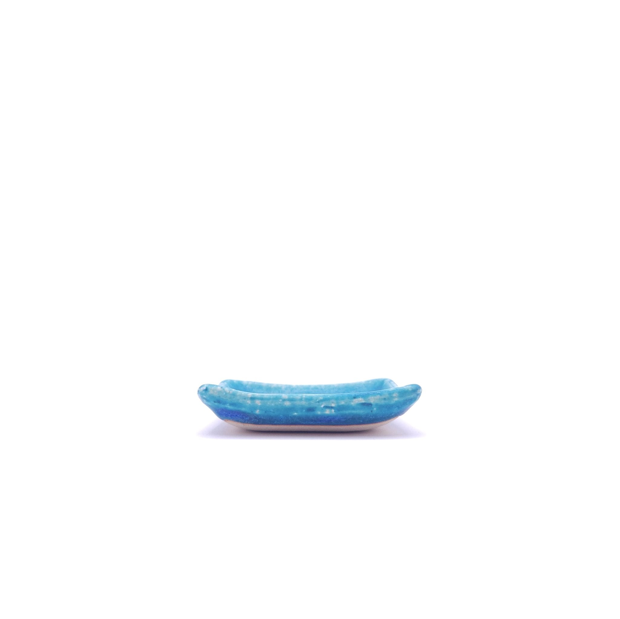 Side view of a turquoise Japanese pottery plate measuring 7.5cm (7.9")