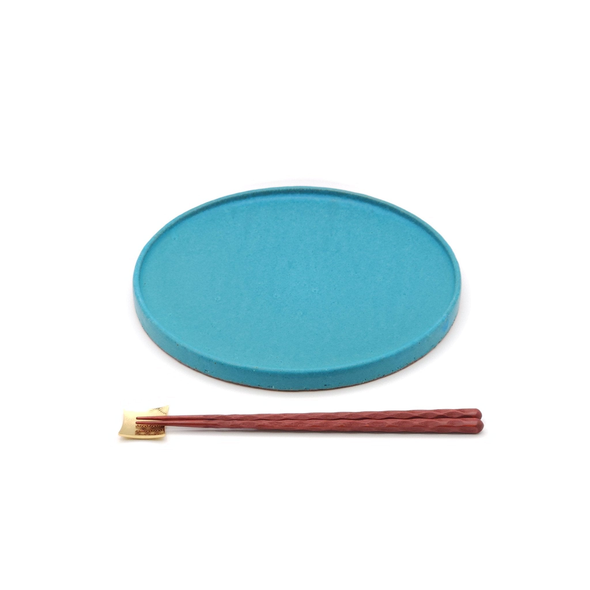 Front view of a turquoise Japanese pottery round Plate 24cm (9.4") with chopsticks.