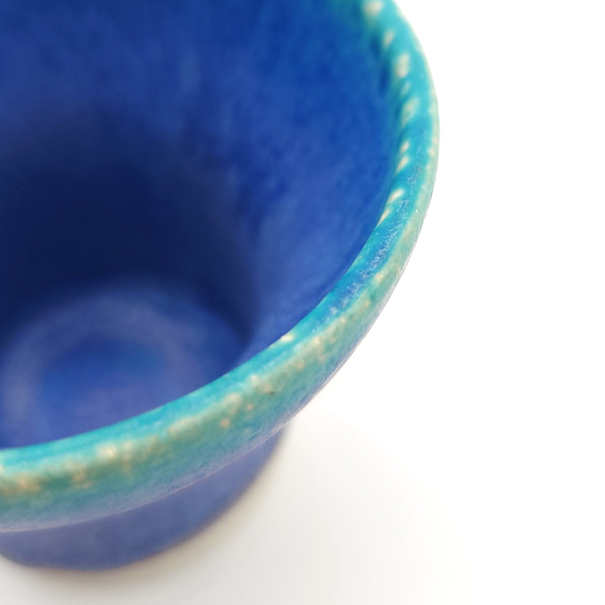 Edge detail of a turquoise Japanese pottery small cup