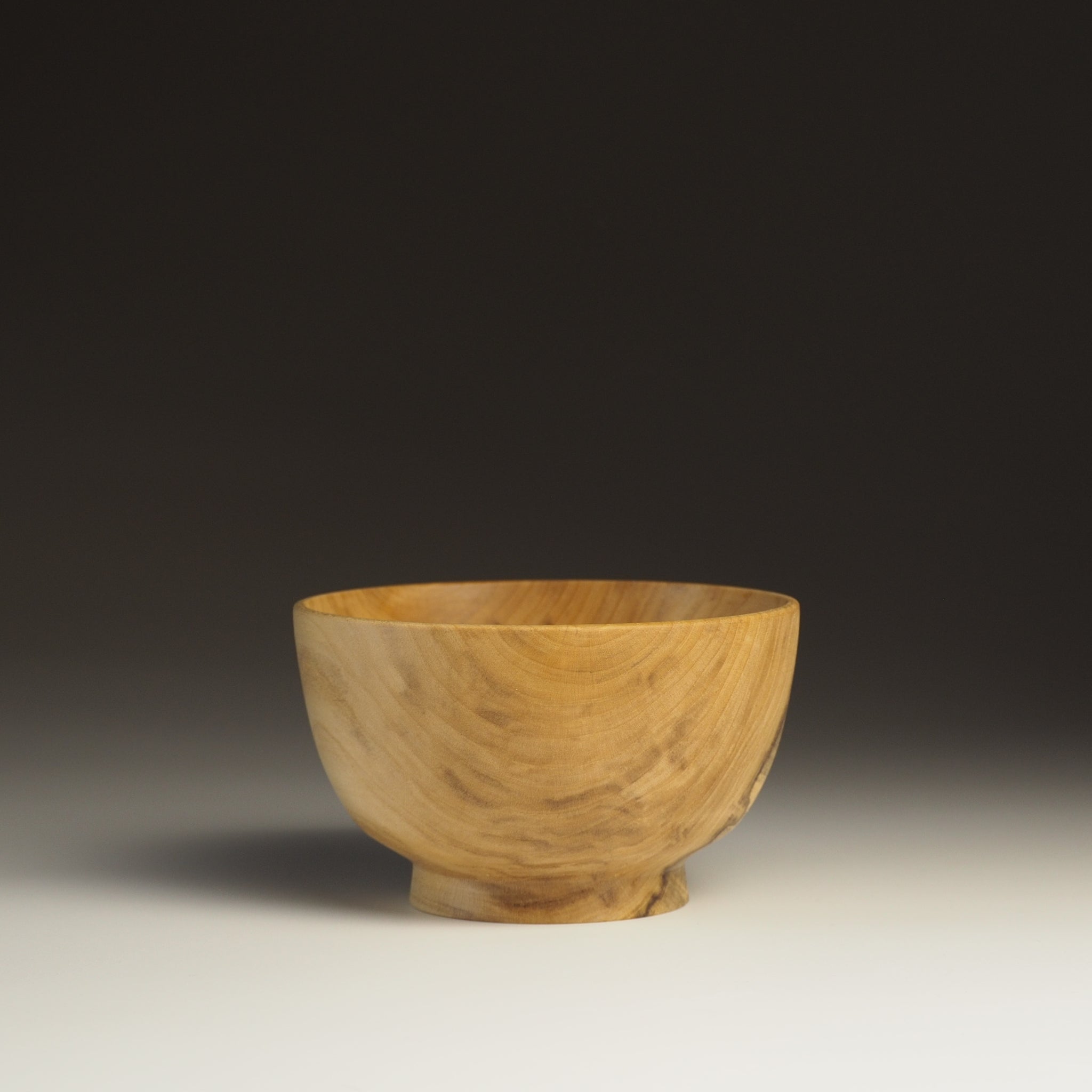 A side view of a Japanese Wooden Bowl on a gradient background. Tsukushi