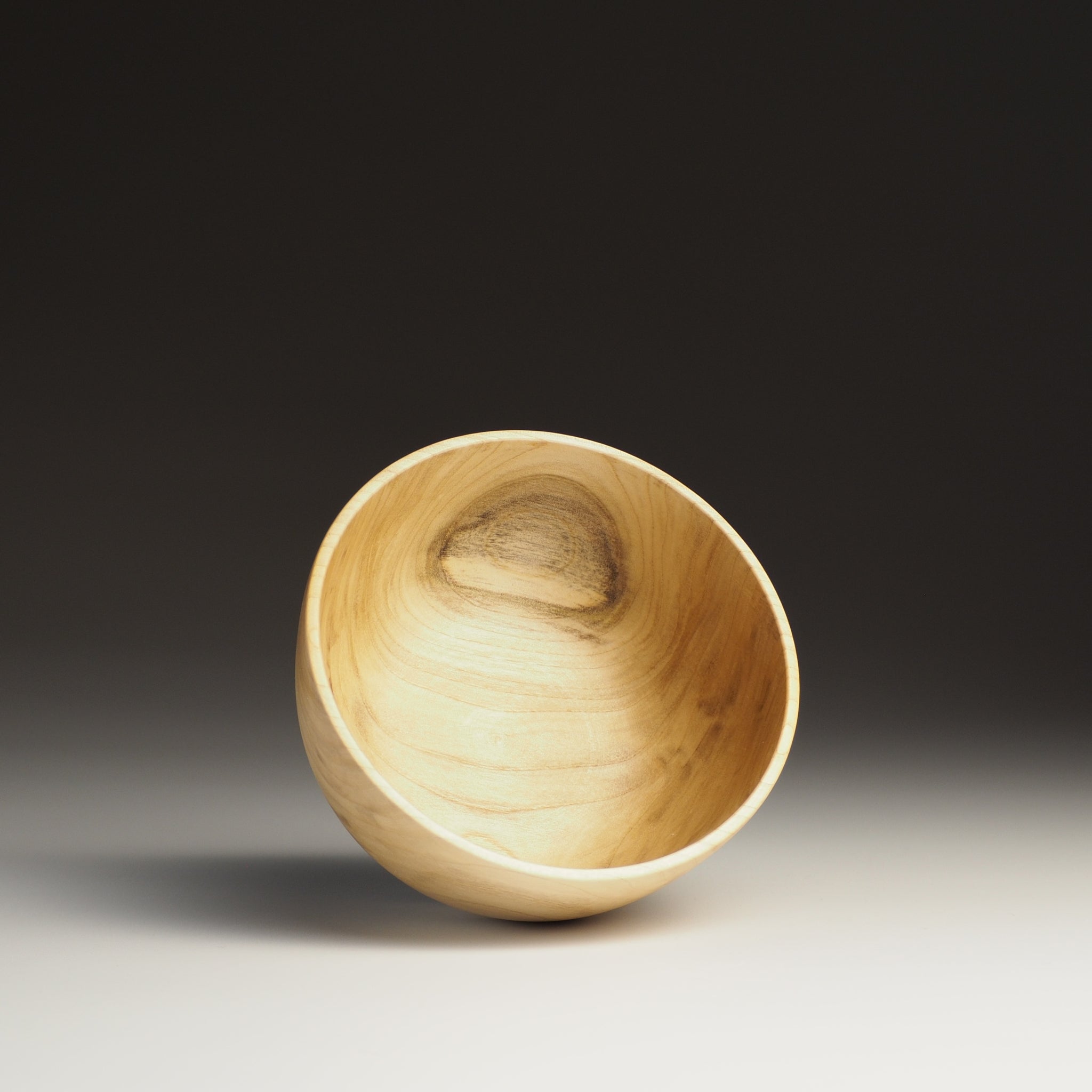 A top view of a Japanese Wooden Bowl on a dark background. Tsukushi