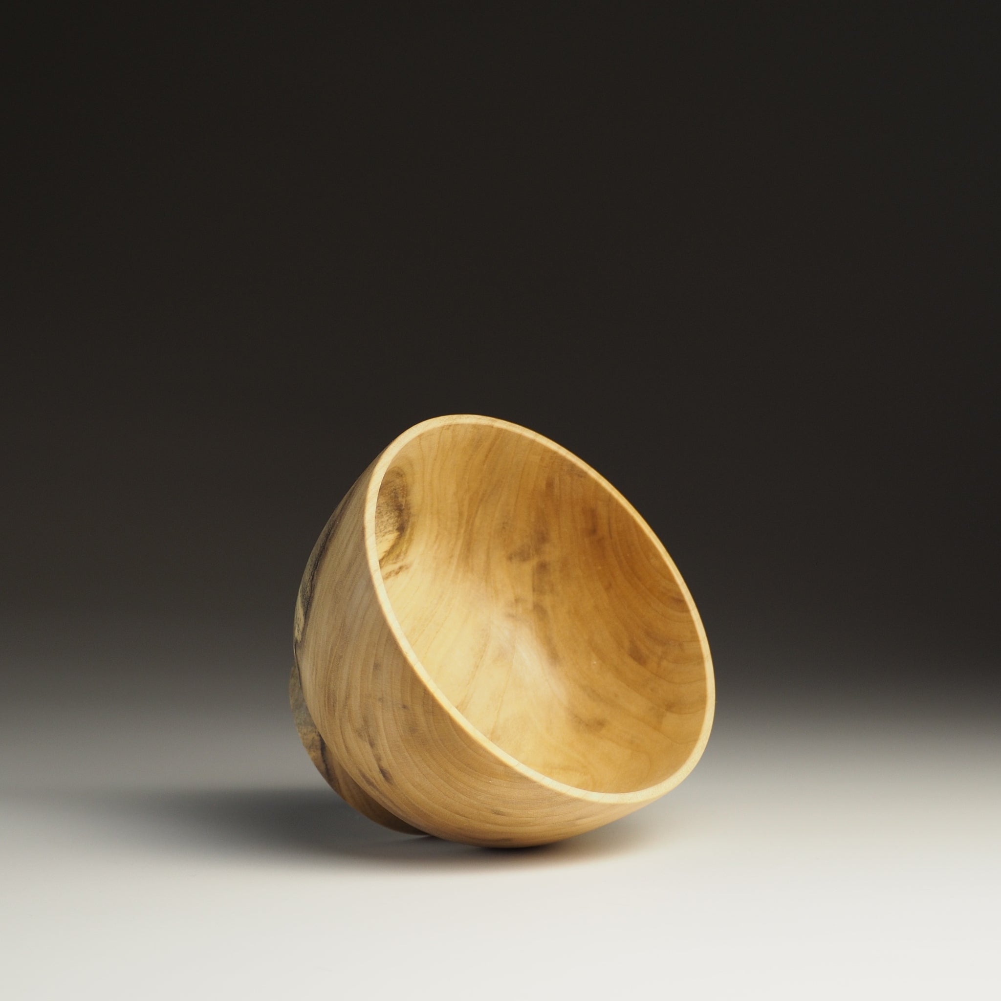 A inside view of a Japanese Wooden Bowl on a black background. Tsukushi