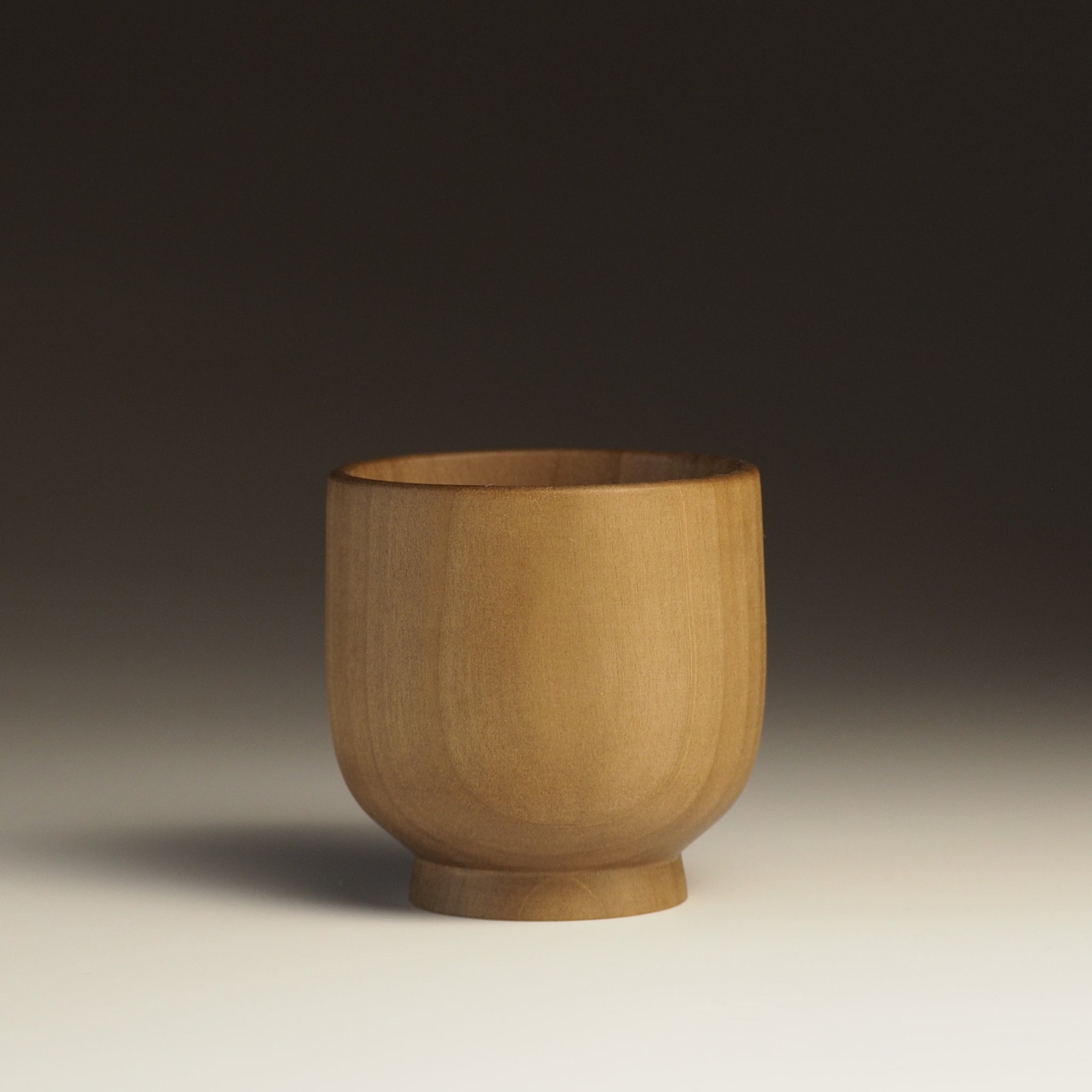 A Japanese handcrafted Wooden Teacup on a gradation background . Tsukushi