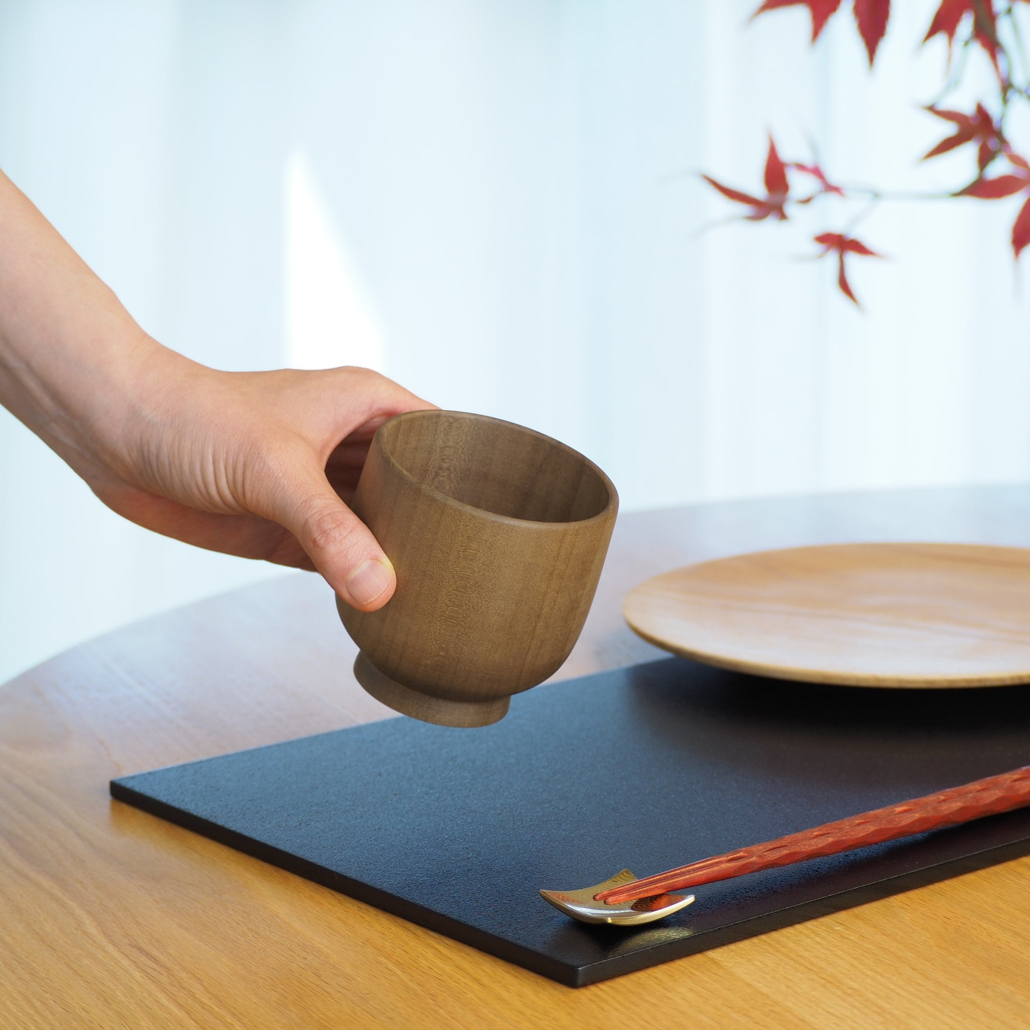 Japanese handcrafted Wooden Teacup on lifestyle background with hand. Tsukushi