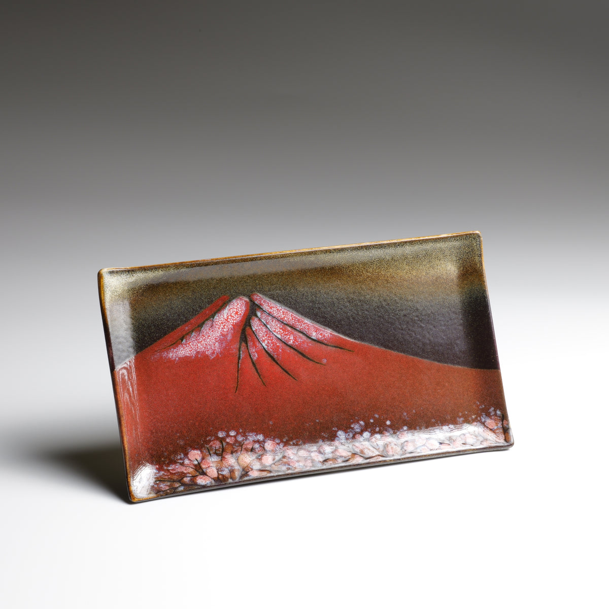 Akafuji handmade rectangular plate with red Mount Fuji motif viewed from a tilted front angle.