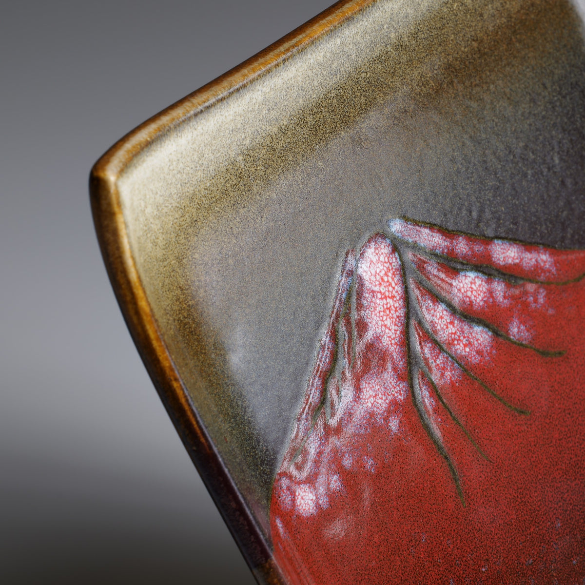 Close-up of the Akafuji Japanese ceramic plate showing the red Mount Fuji design, white snow details, and contrasting earthy glaze.