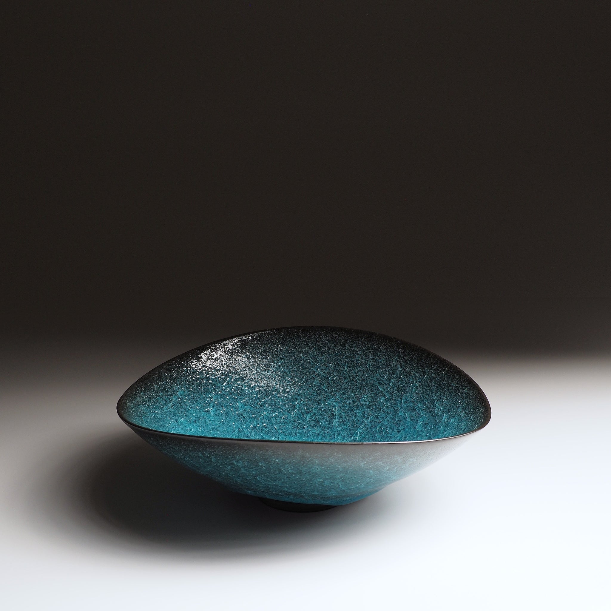Aonami waved serving bowl, full side view showing asymmetric ceramic form and teal kannyu glaze. Taichi Kawai, Usurai Pottery, Japan.