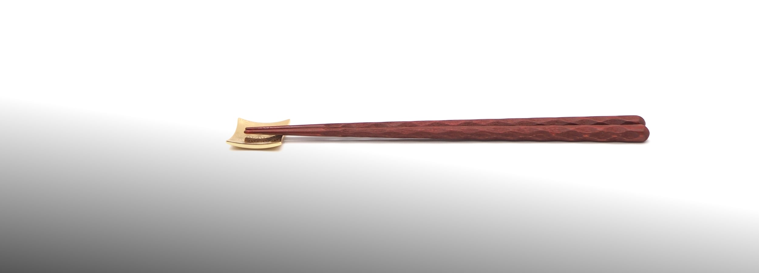 A pair of Japanese wooden chopsticks shown horizontally on a clean white background.