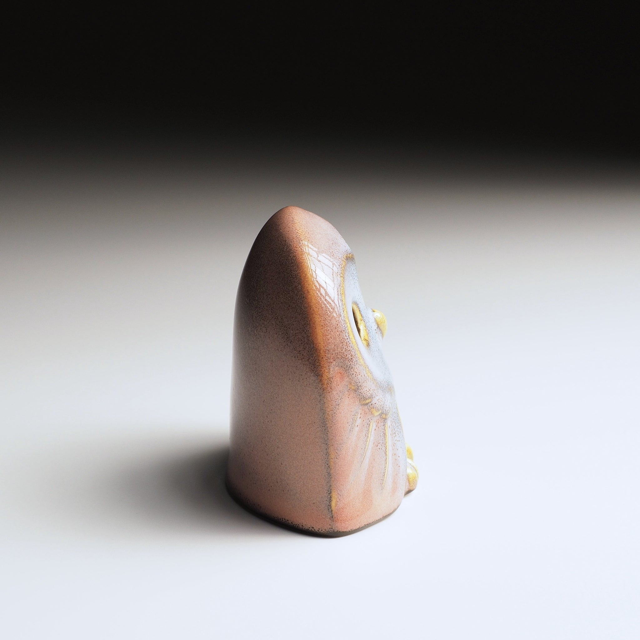 Engifuku owl figurine by Kazuhiro Kojima seen from the right side, pink and grey speckled glaze, golden details, hollow eyes.