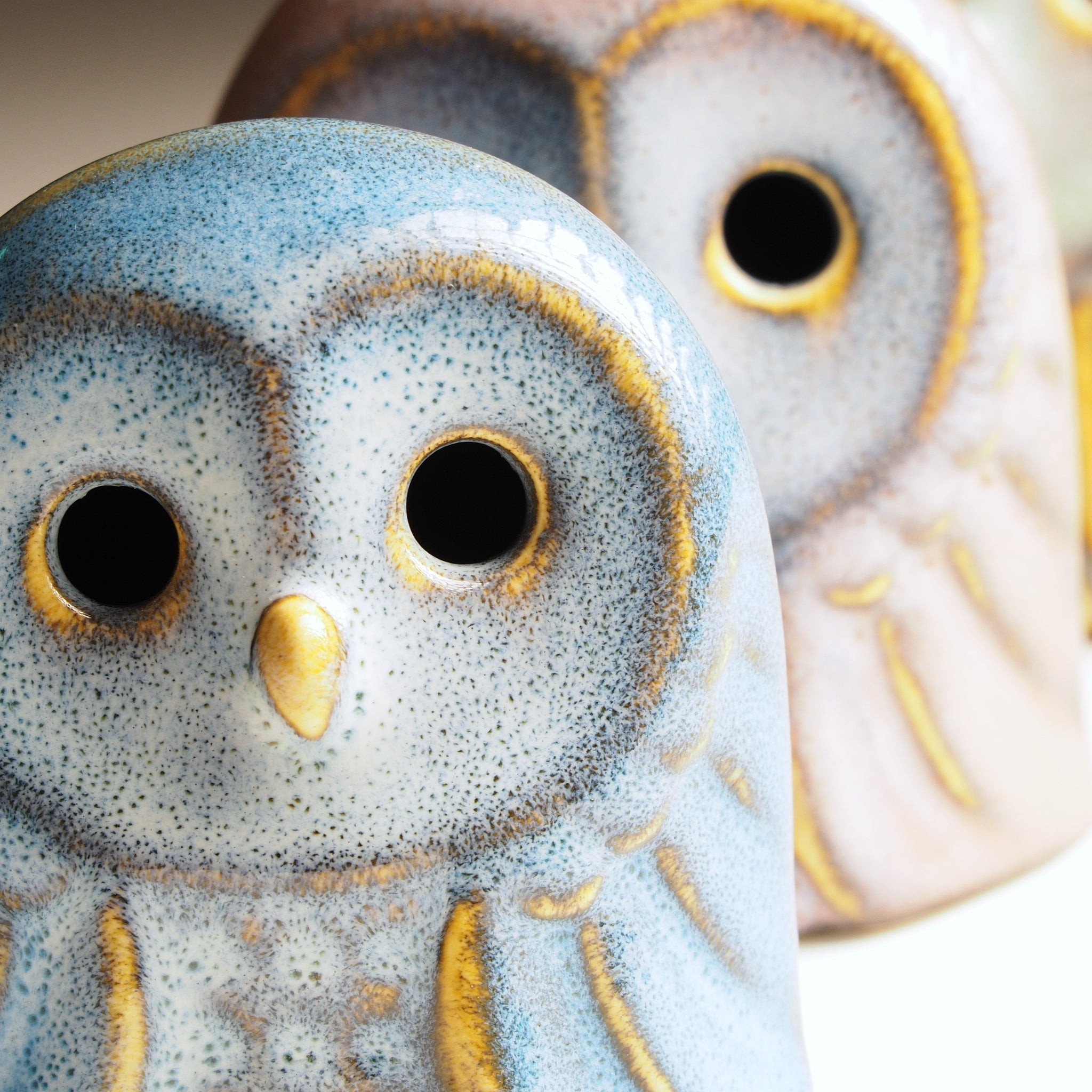 Close-up of a Japanese ceramic owl with speckled gray and blue design.