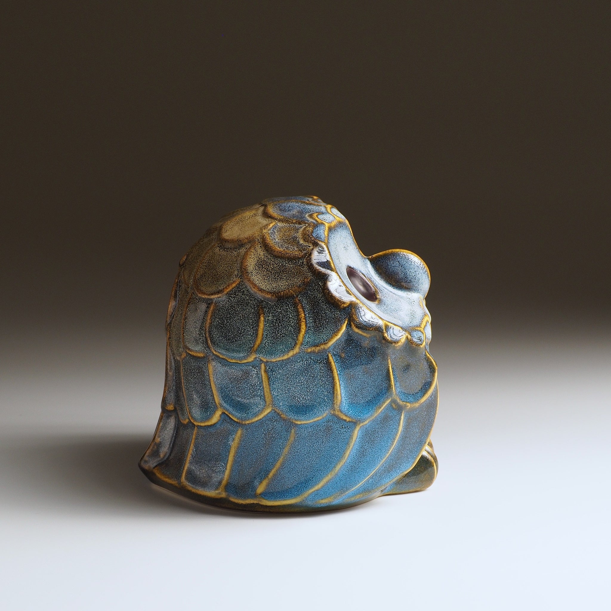 Opposite side view of the medium Fukumori ceramic owl ornament with blue glaze and textured feather pattern