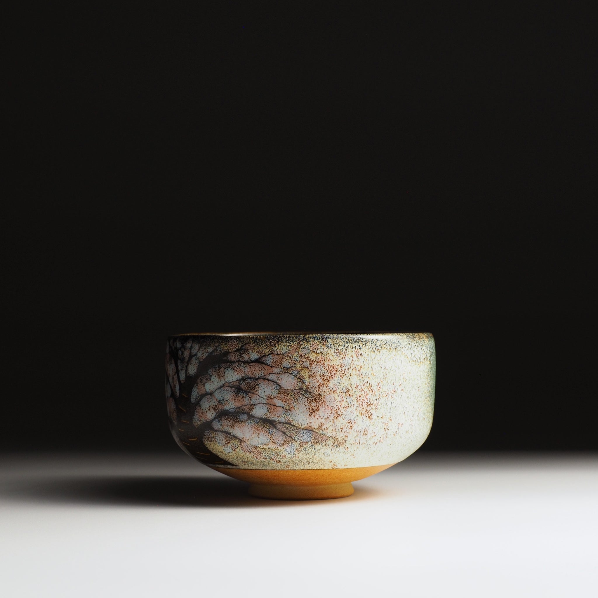 Hanagumo matcha bowl, sakura tree motif in muted tones, Nanasai Tenmoku glaze, Taro Kojima Japan