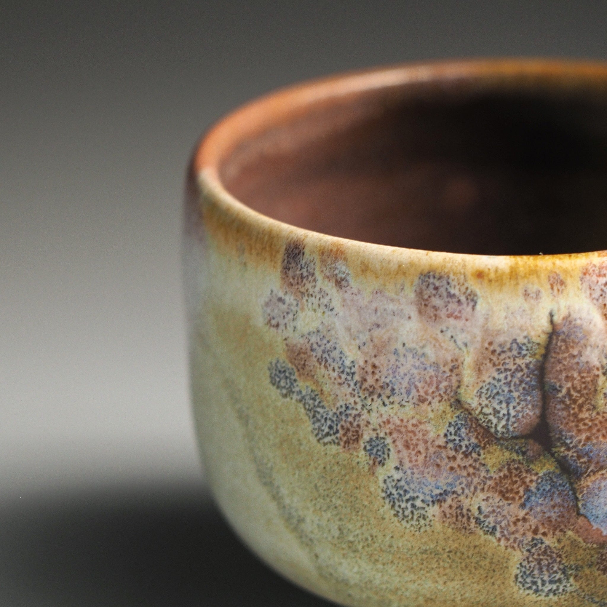 Close-up of a Japanese ceramic sake cup rim with sakura decorations