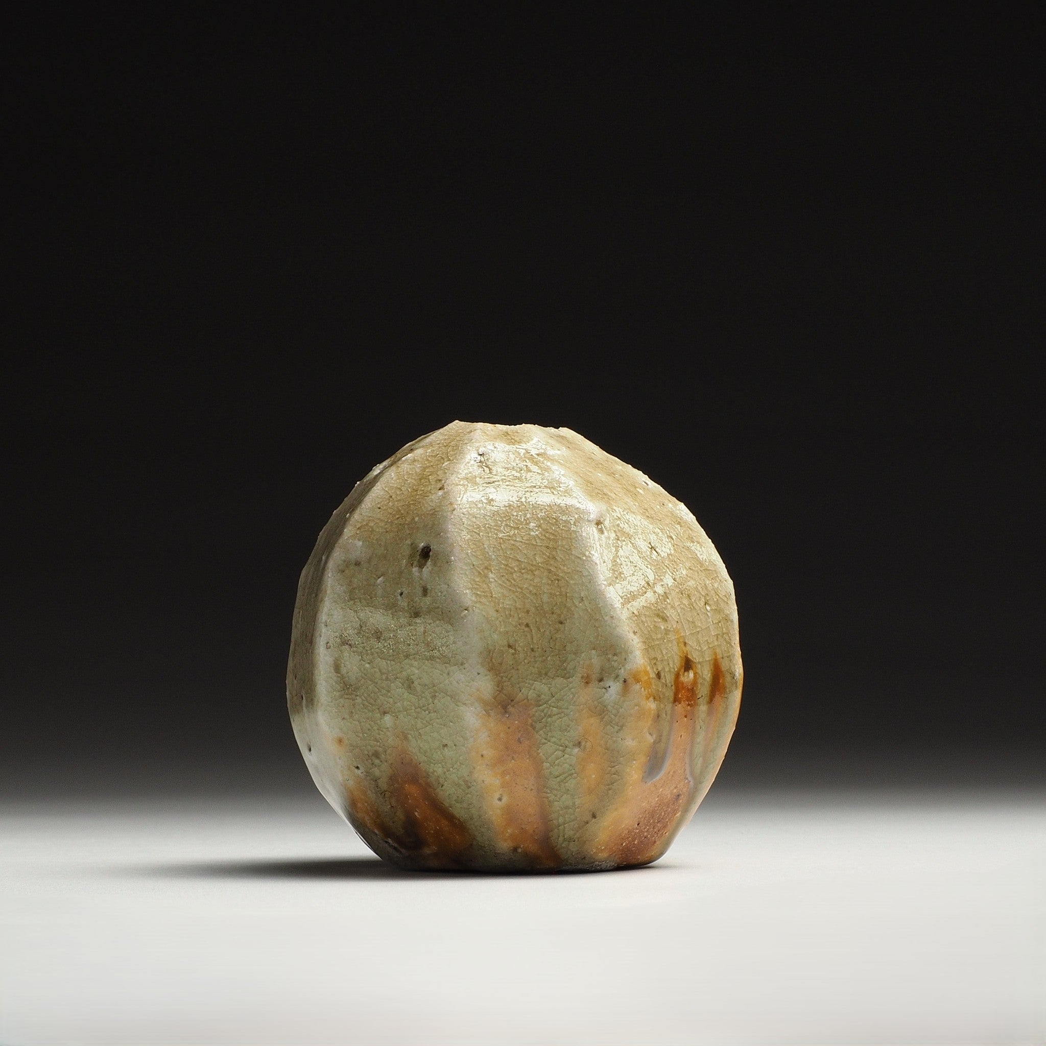 Kokeishi handmade Shigaraki flower vase with a rounded faceted body and naturally varied beige and orange-brown tones.