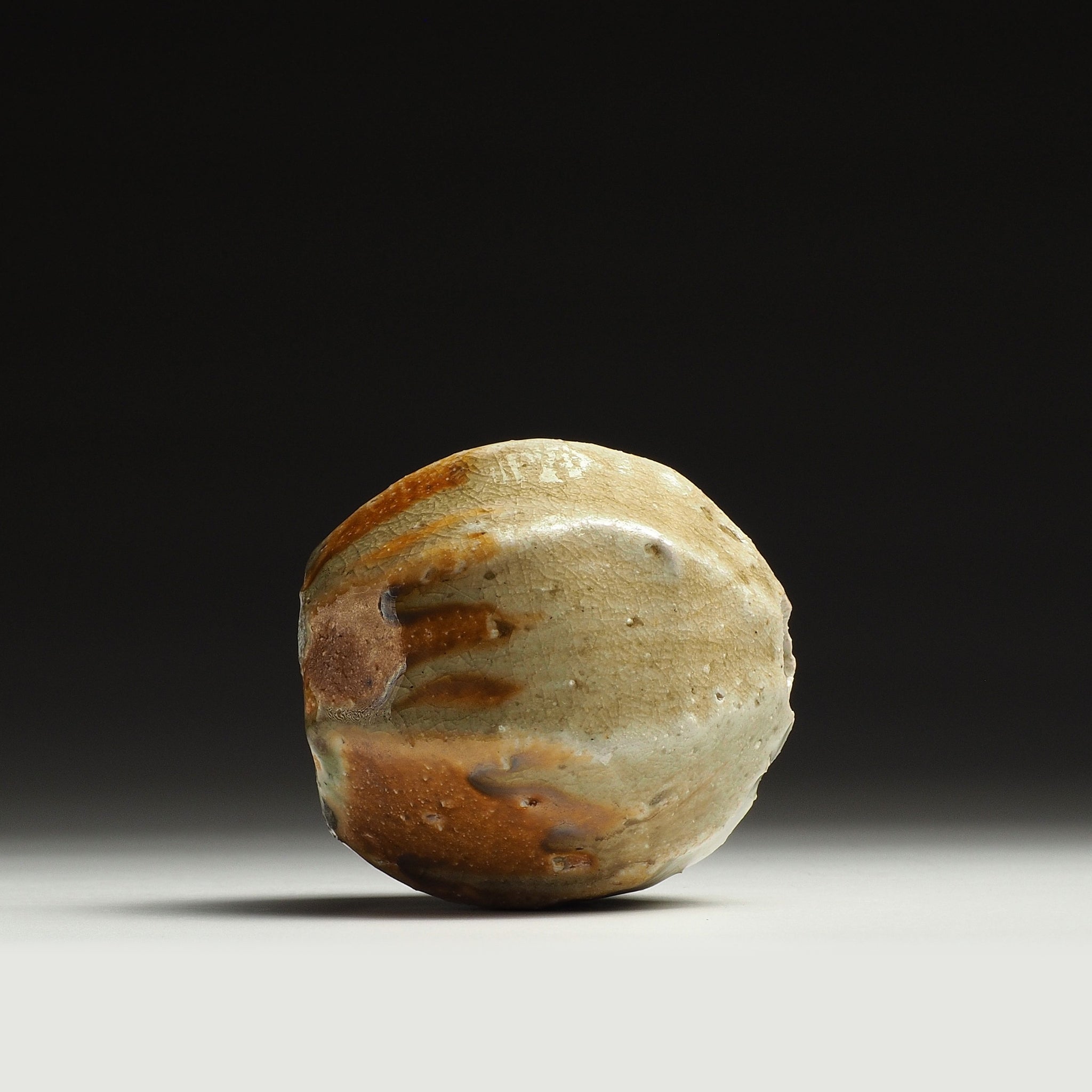 Side view of the Kokeishi Shigaraki flower vase showing horizontal beige and warm orange-brown firing patterns.