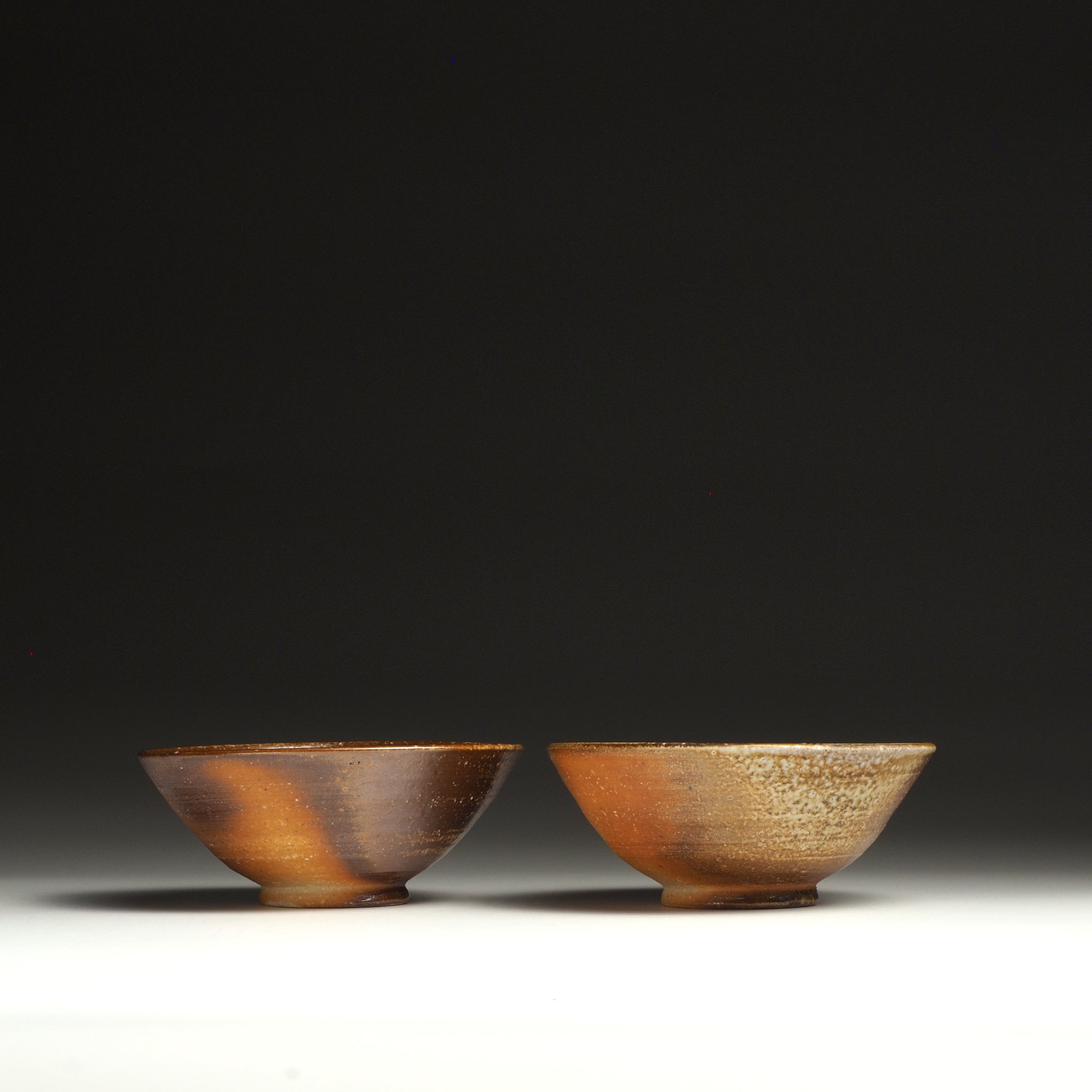 Two Mizuho Shigaraki rice bowls side by side, showing their contrasting brown and beige firing tones.