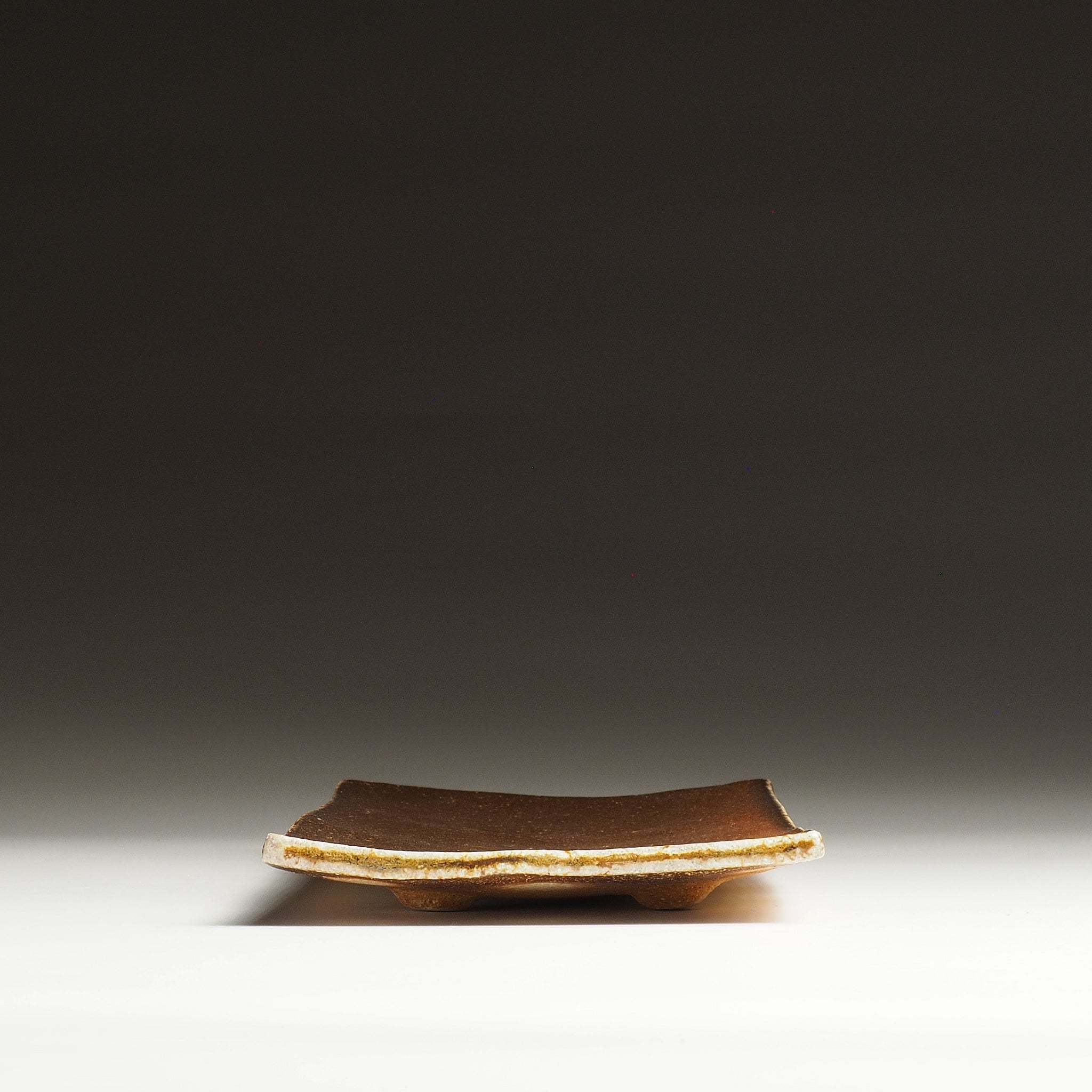 Front view of the Nagafune handmade Shigaraki serving plate showing its shallow rectangular form and raised center.