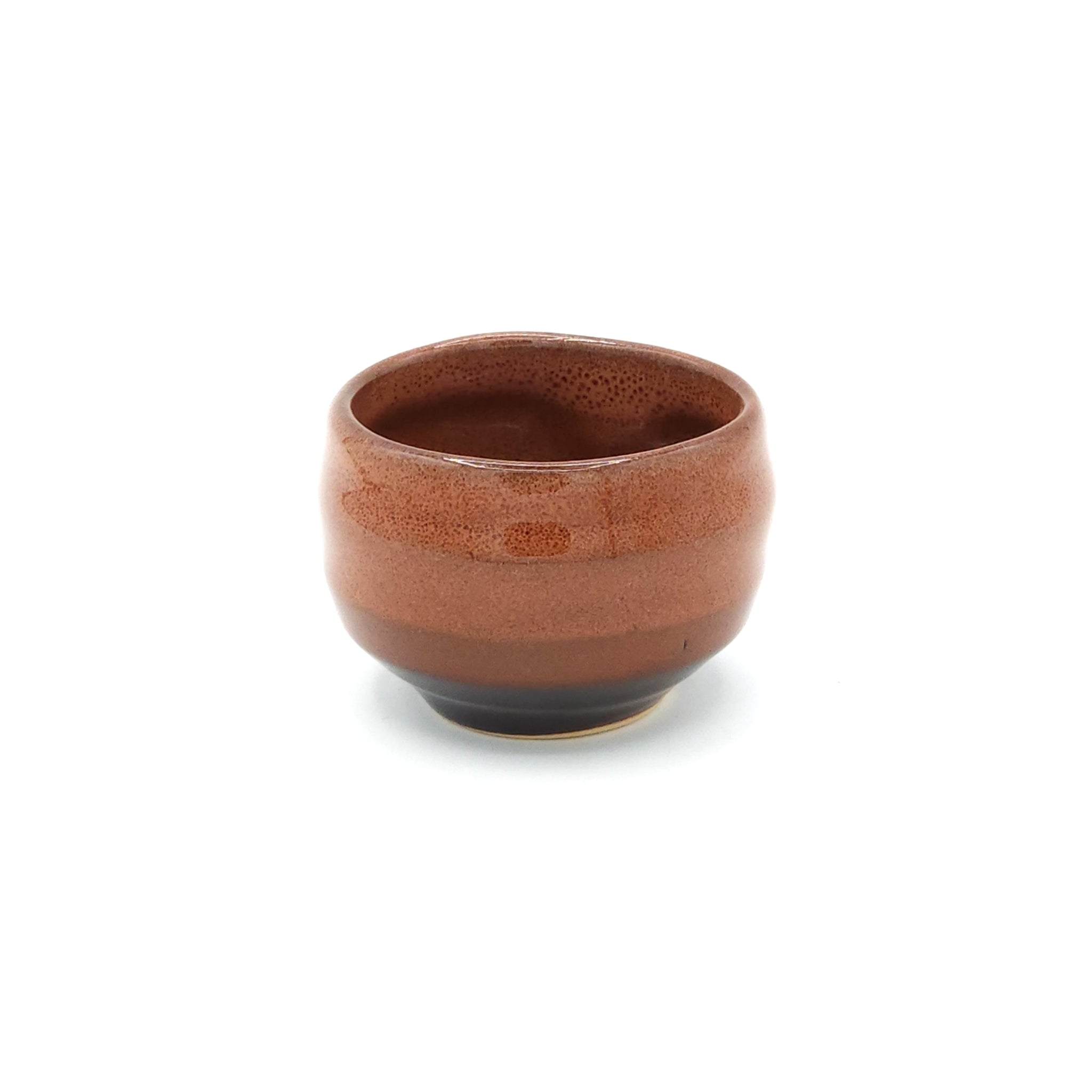 A side view of a Japanese ceramic round sake cup (brown). Tsukushi