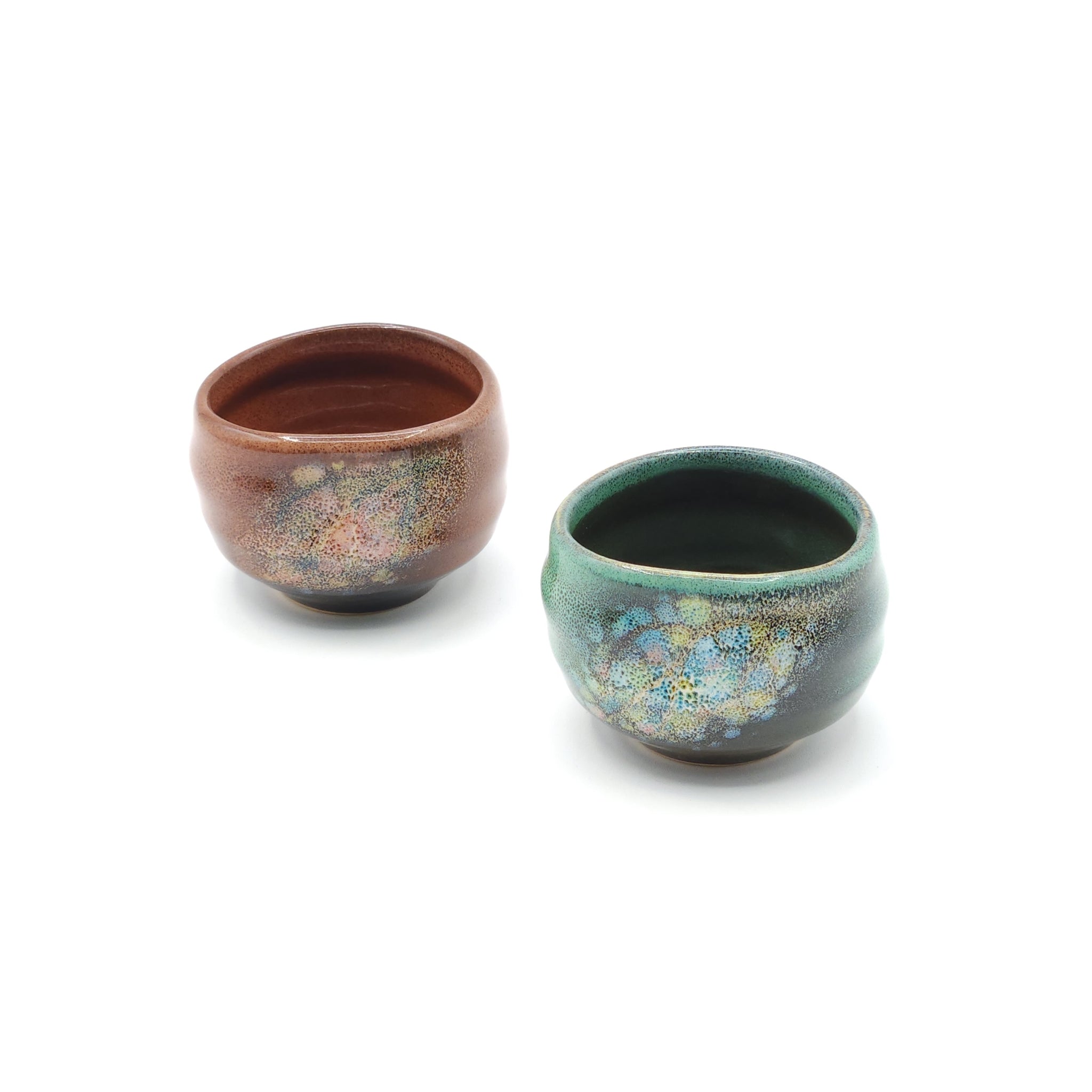 A set of two round Japanese ceramic sake cups in earthy brown and green. Tsukushi