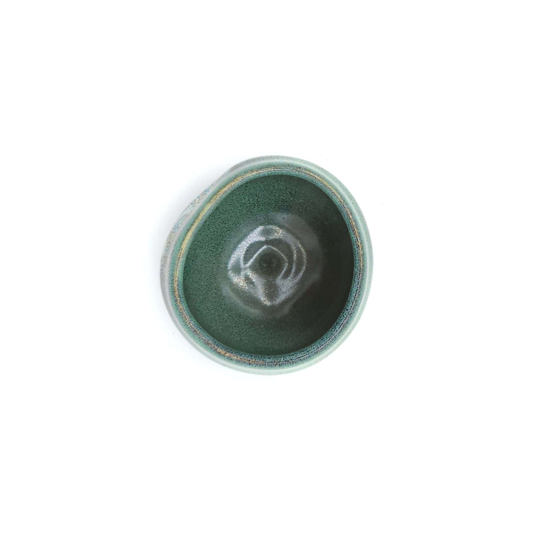 A top view of a Japanese round sake cup (green). Tsukushi