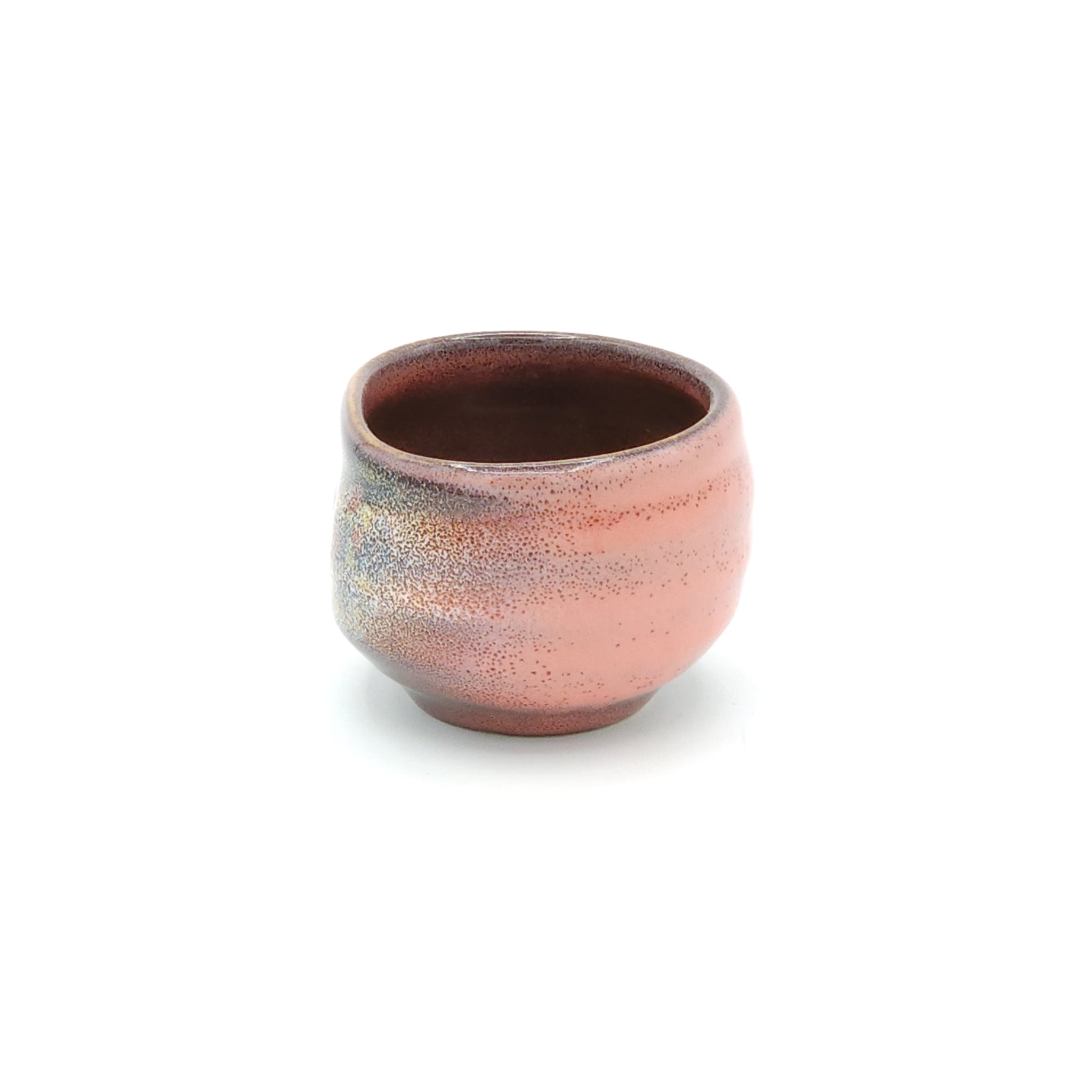A side view of a pink Japanese round sake cup. Tsukushi