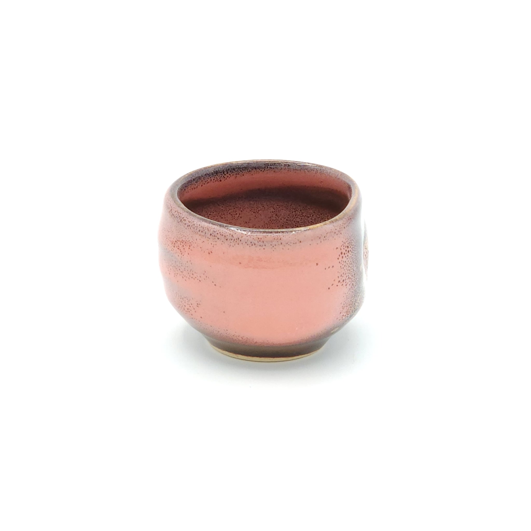 A lateral view of a pink Japanese round sake cup.Tsukushi