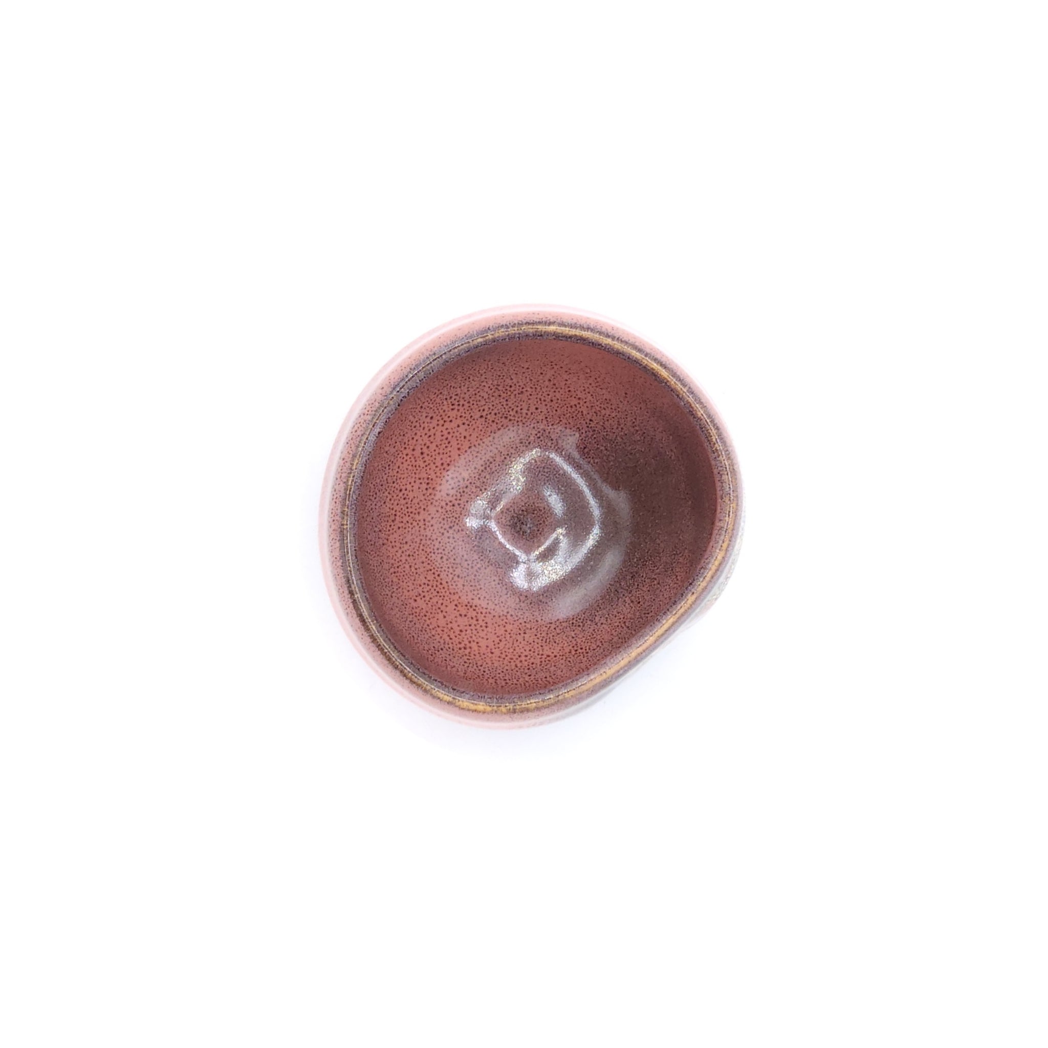 A top view of a pink Japanese round sake cup. Tsukushi