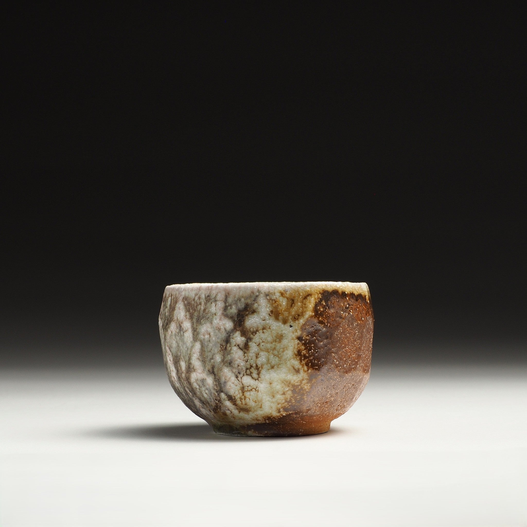 Front view of a Ryoen Shigaraki yunomi with irregular beige glaze over a warm brown ceramic body.