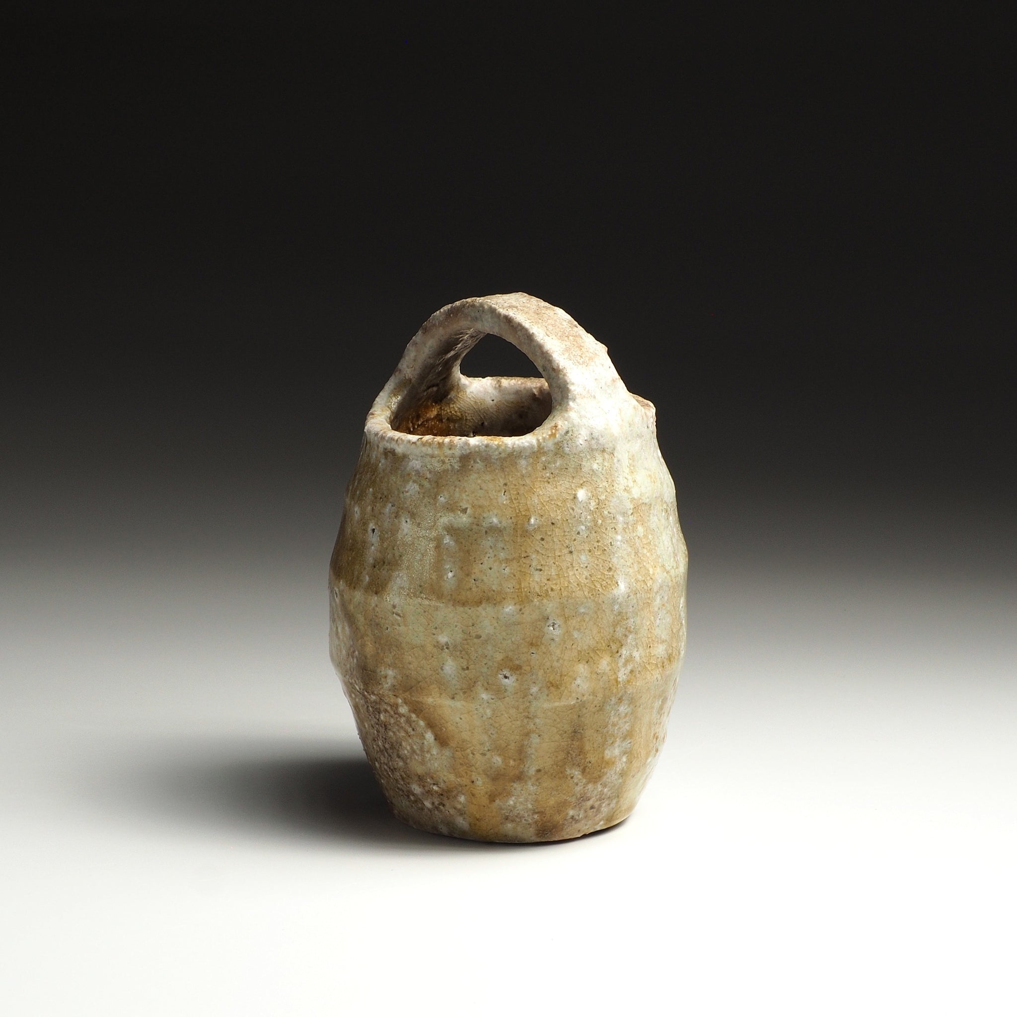 Setsugan handmade Shigaraki flower vase with loop handle, rounded body, and naturally varied beige and brown surface.