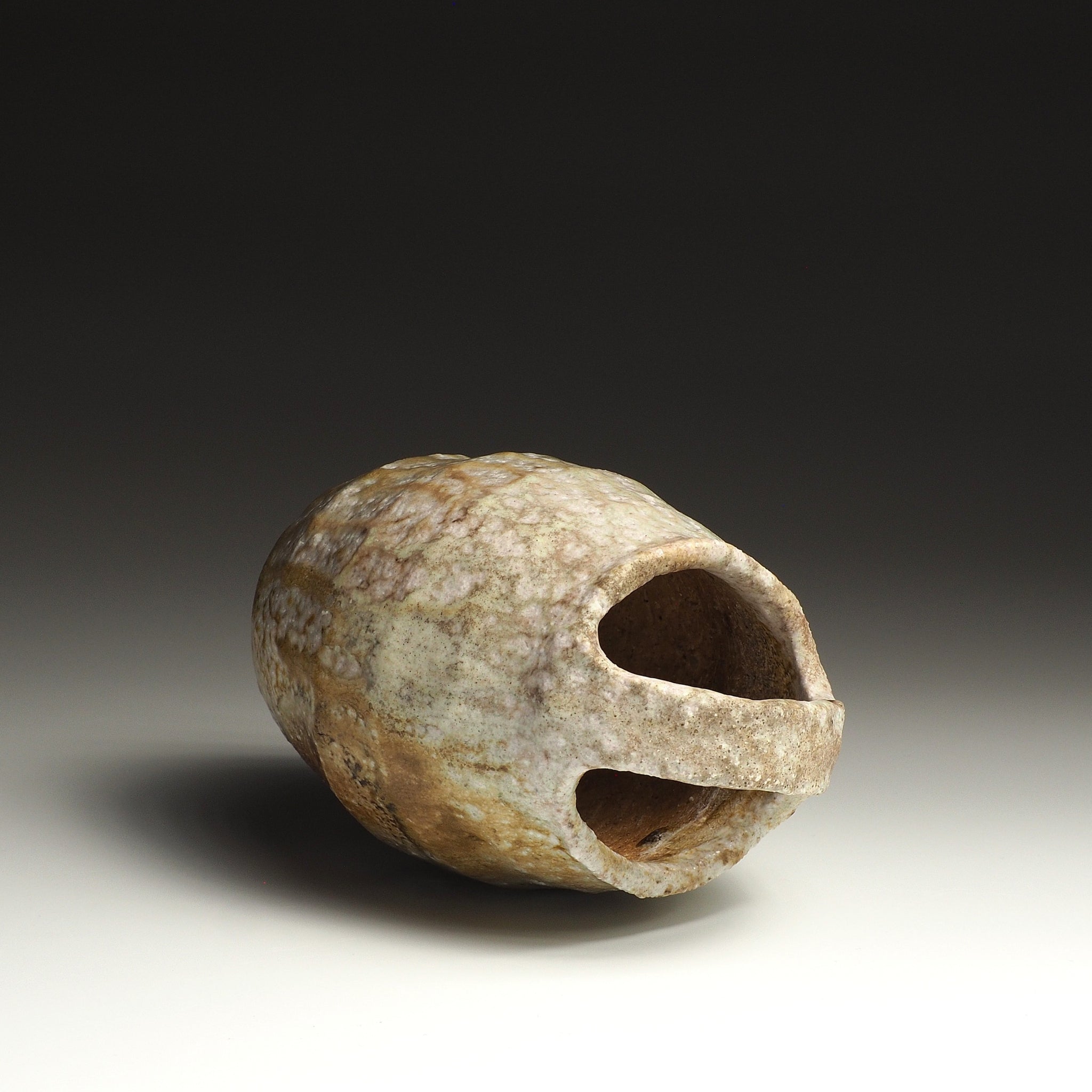 Setsugan Shigaraki flower vase resting on its side, showing the opening, loop handle, and rounded handmade form.