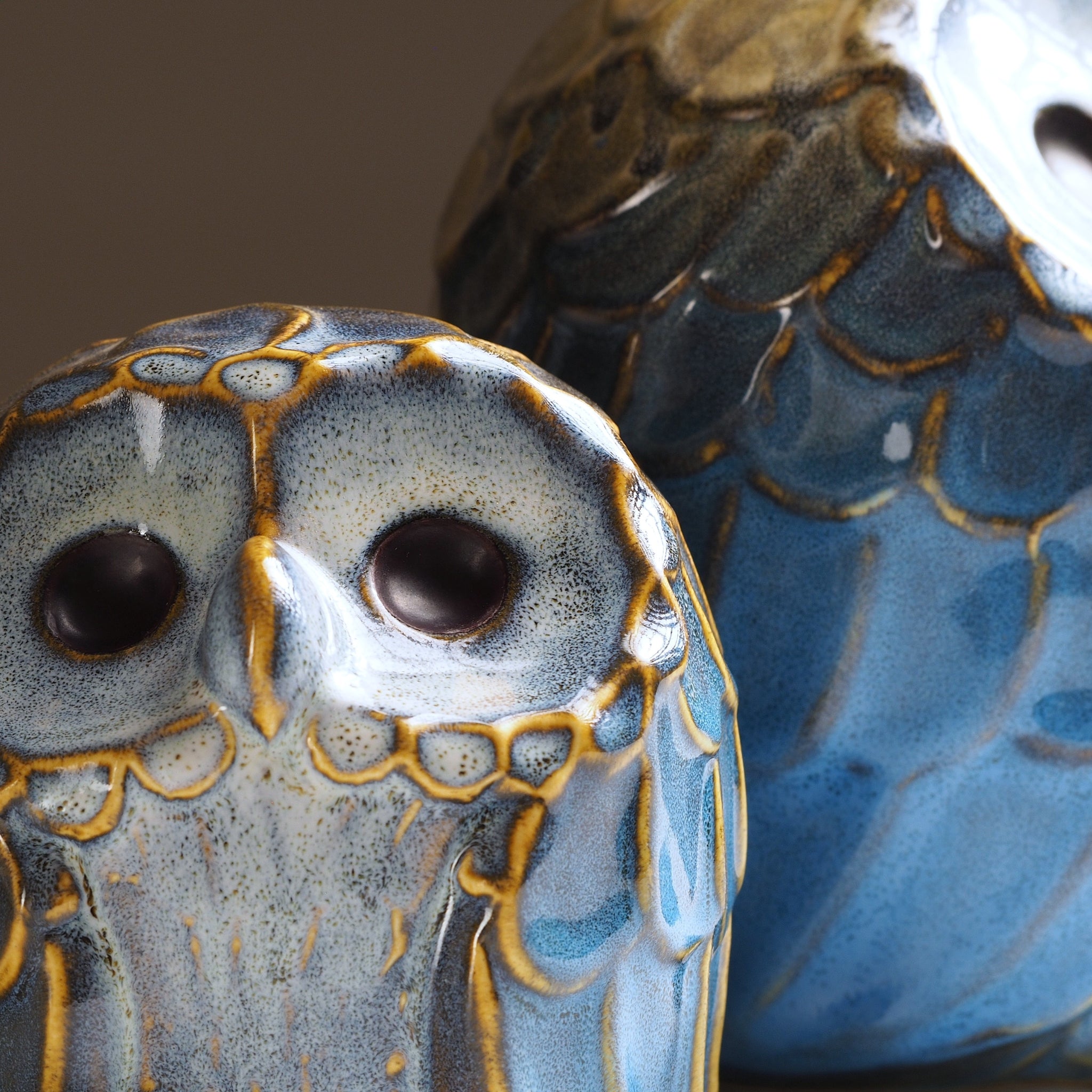 Close-up of the Sofuku owl pair showing the smaller owl’s face and the larger owl’s blue feather pattern