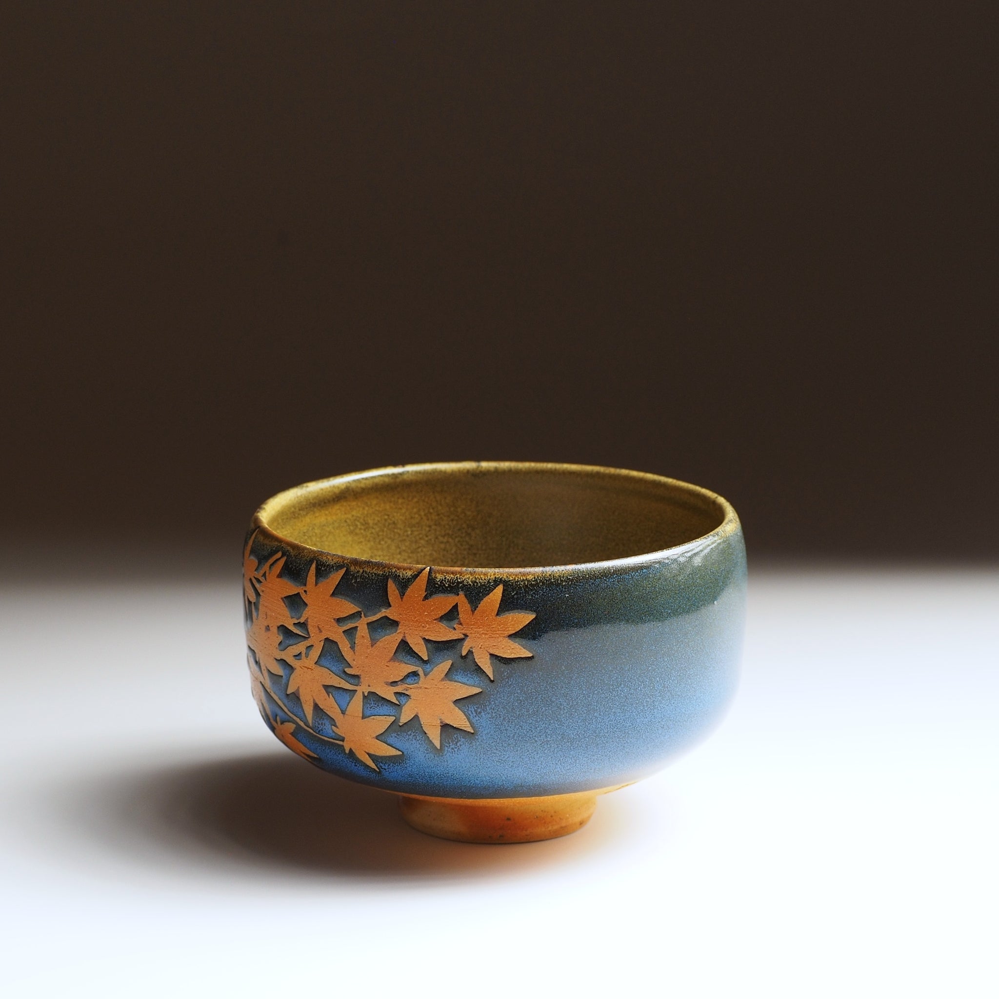 Japanese Ceramic SoShu matcha bowl with leaf pattern on a dark background