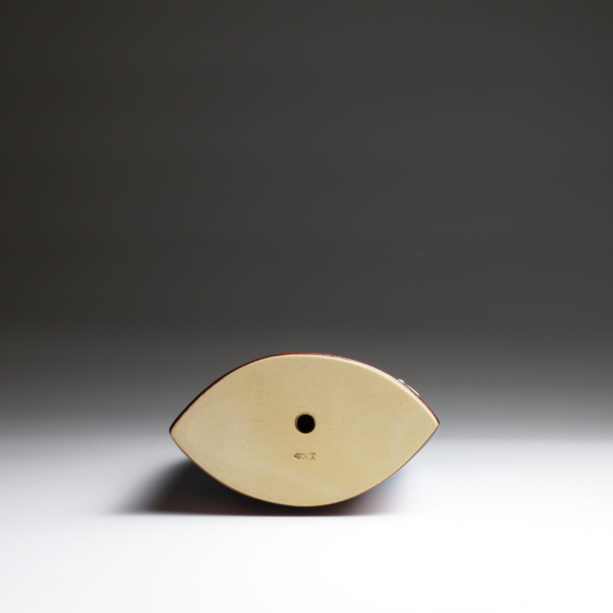 Base view of the Tsukimi ceramic ornament by Kazuhiro Kojima, showing the unglazed ceramic underside and kiln mark.