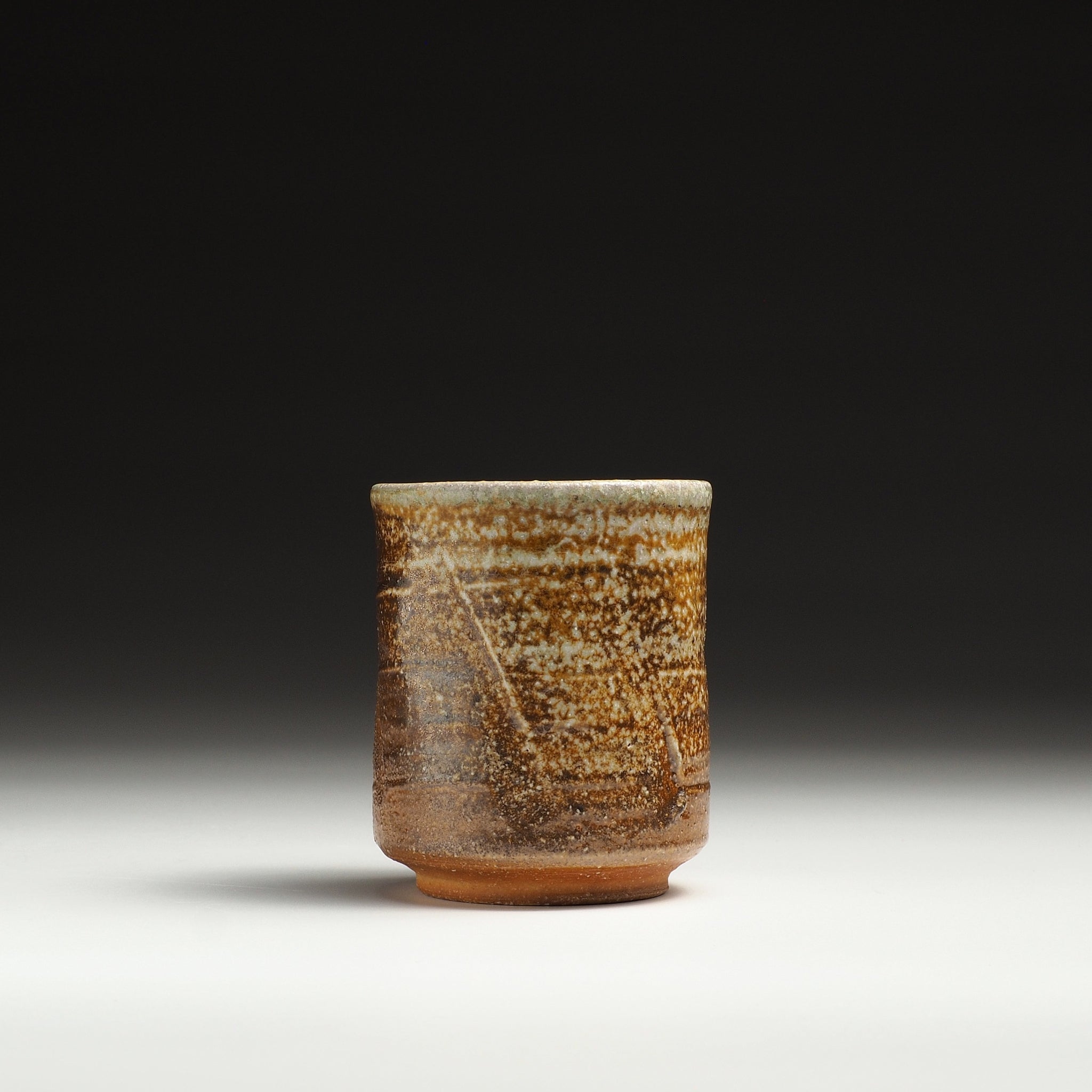 Single Yubae handmade Shigaraki yunomi with a cylindrical form and textured beige and brown surface.
