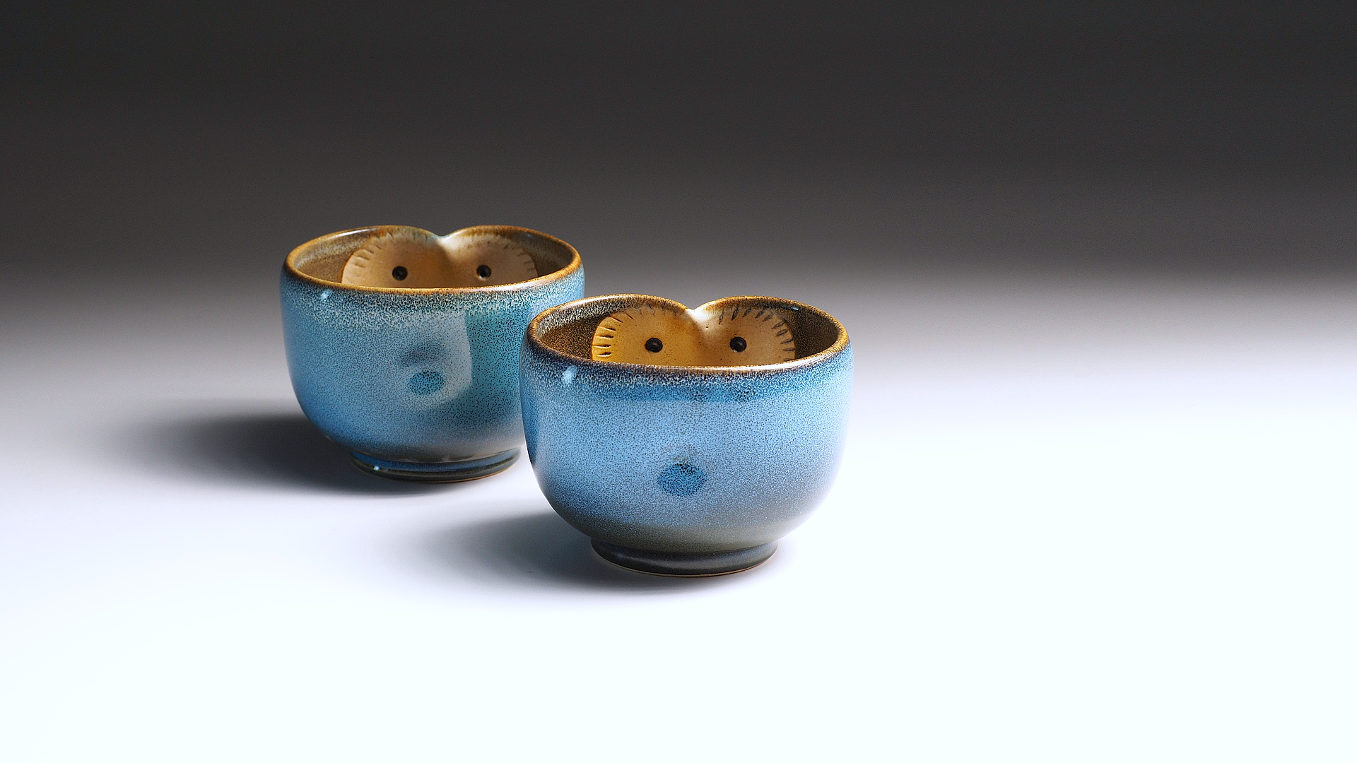 Two handcrafted yunomi teacups featuring owl motifs. Tsukushi