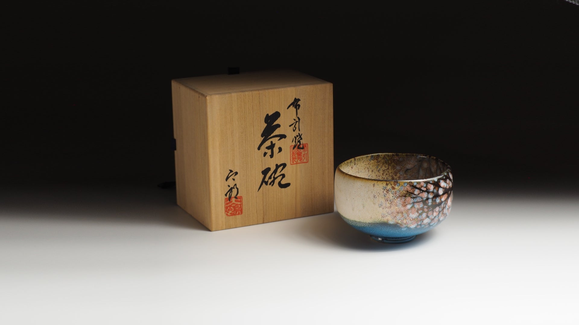Pottery matchawan with wooden box on a dark background