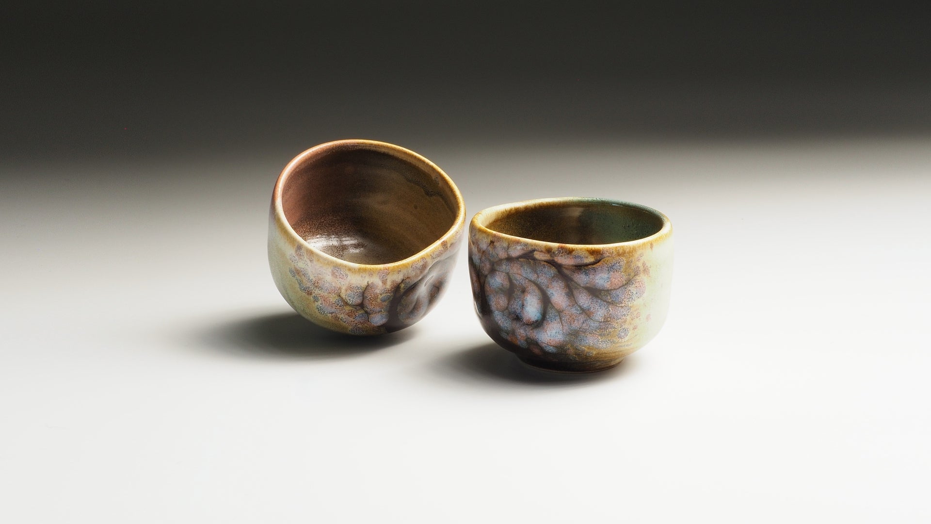 Artisan Japanese guinomi sake cups with flower decorations.