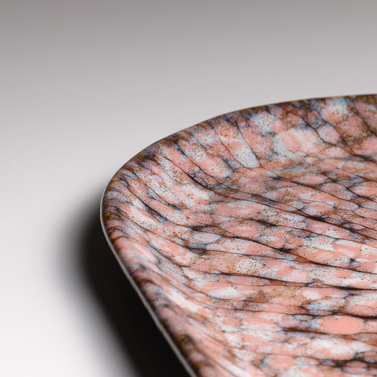 Details of the Japanese handmade ceramic plate Hanami with sakura decorations and pink shades.