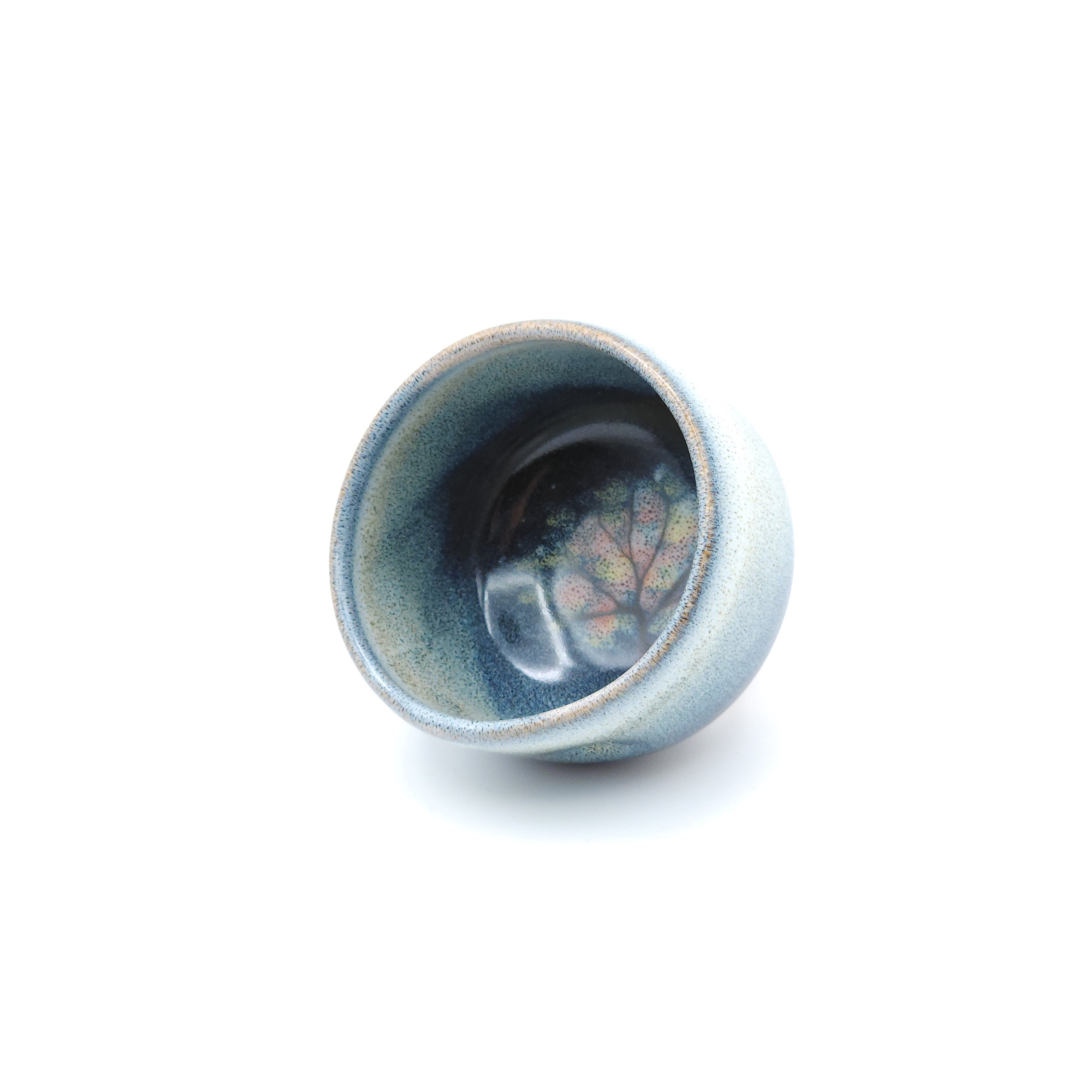 Authentic Japanese pottery teacup with tree decoration. blue and white color. (front side view 1).