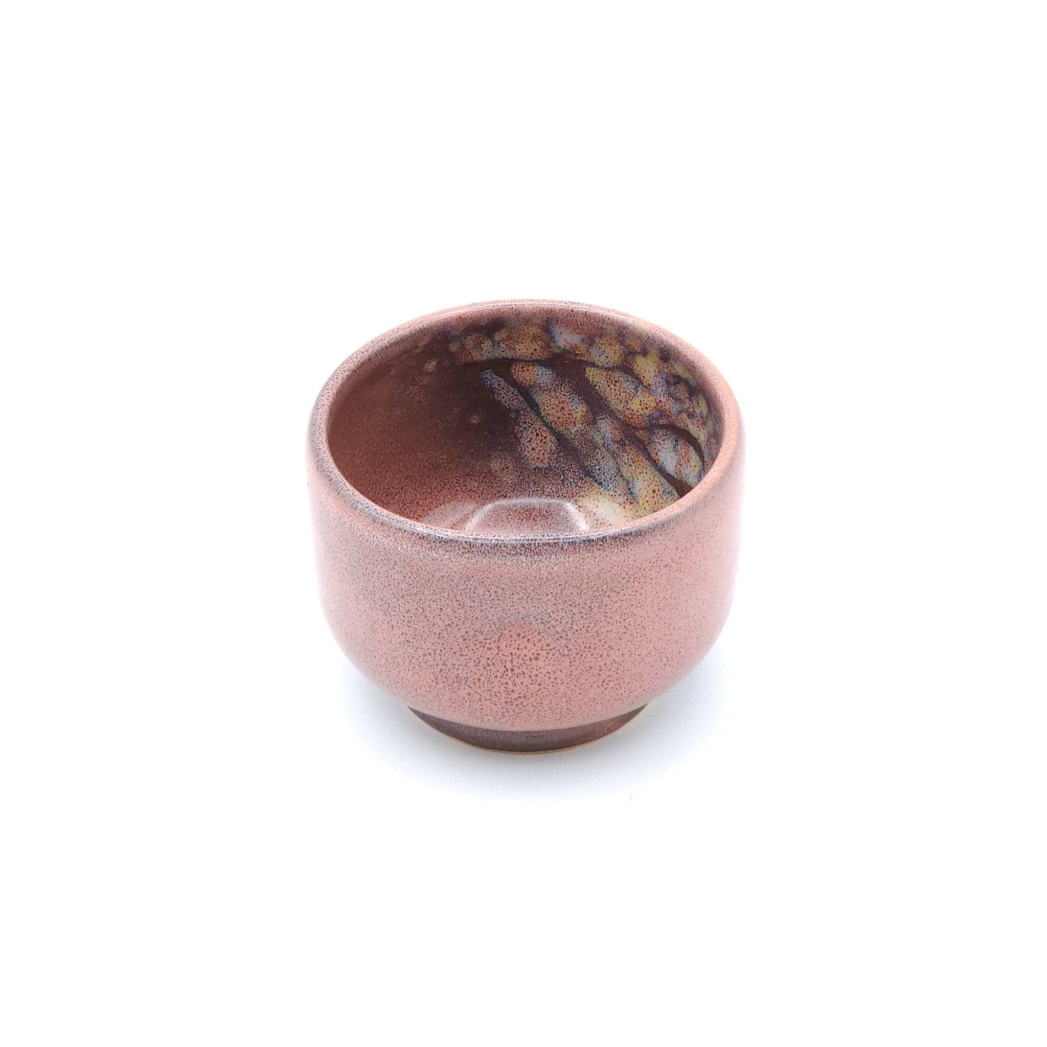 Authentic Japanese pottery teacup with tree pattern decoration. pink color. (front side view 1).