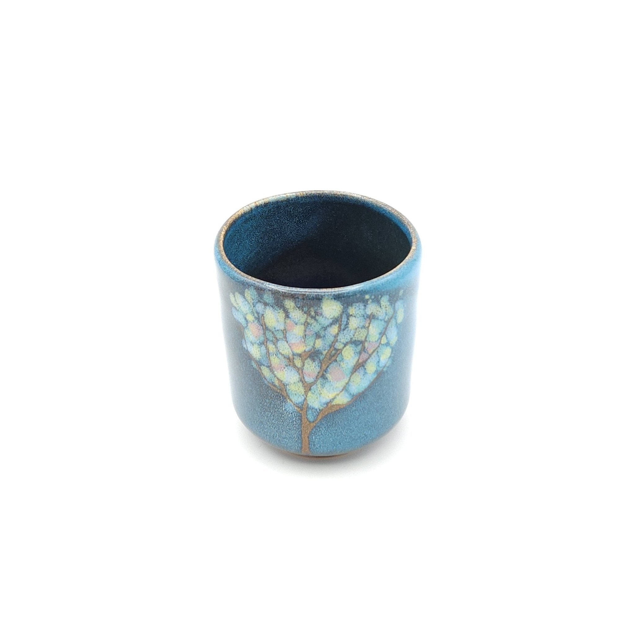 Authentic Japanese pottery teacup tall with tree pattern decoration. blue color. (side view 1).